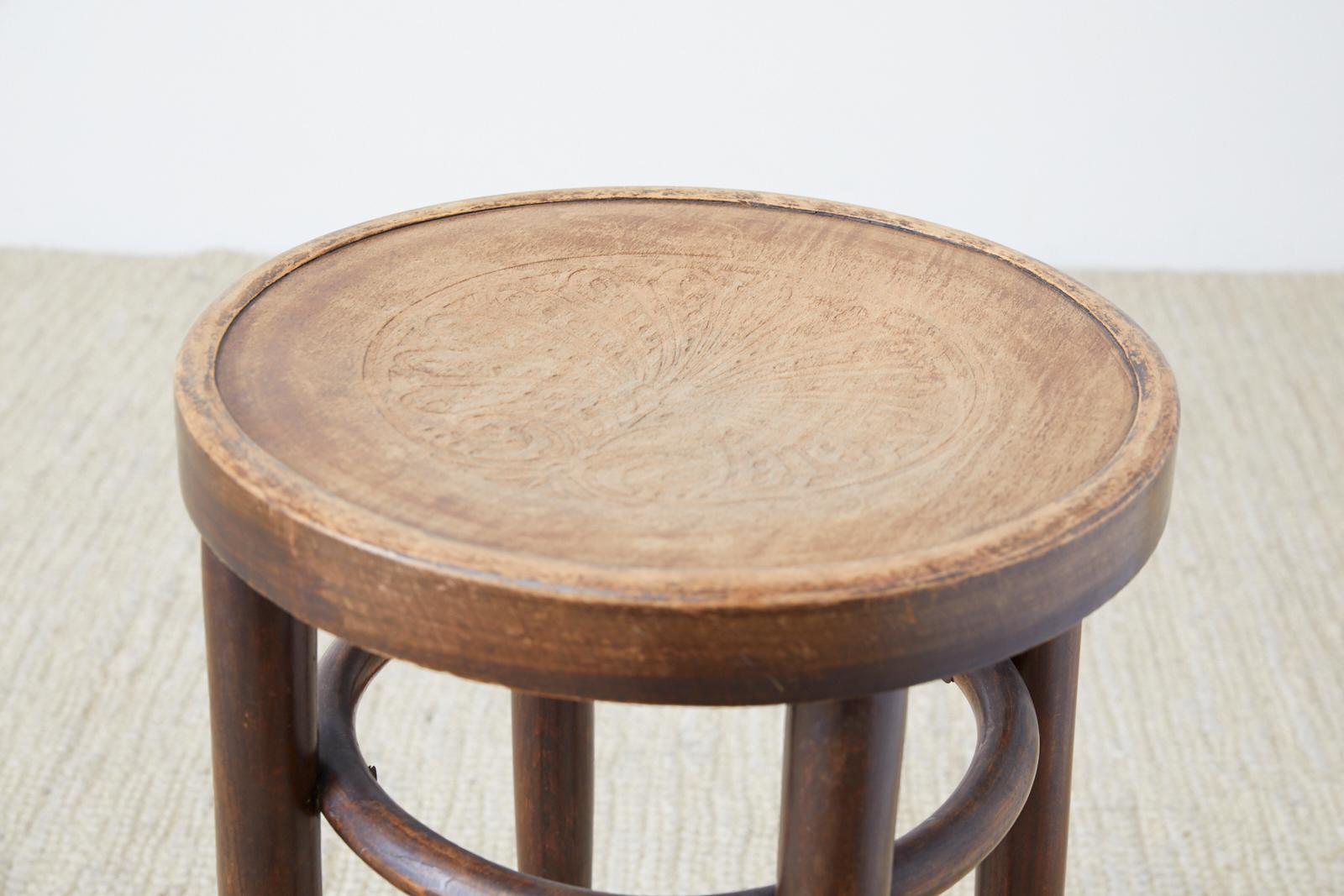 Round wood bentwood stool attributed to Thonet. Features an embossed palmette design on top.