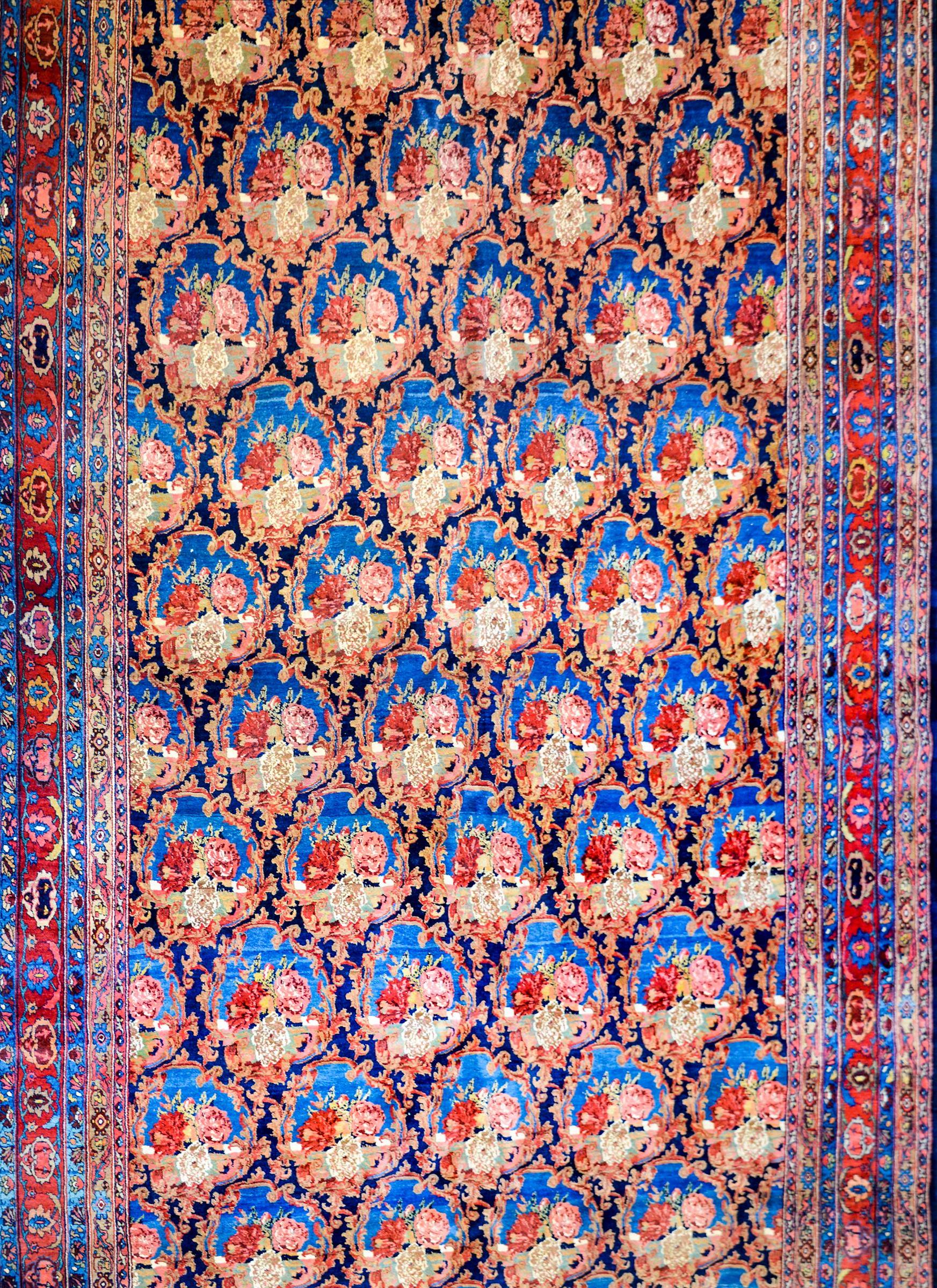 An early 20th century Persian Bidjar rug with a beautiful all-over lattice pattern with large-scale roses on a light indigo background. The border is complex, composed of multiple matching pairs of petite floral patterned stripes and a central
