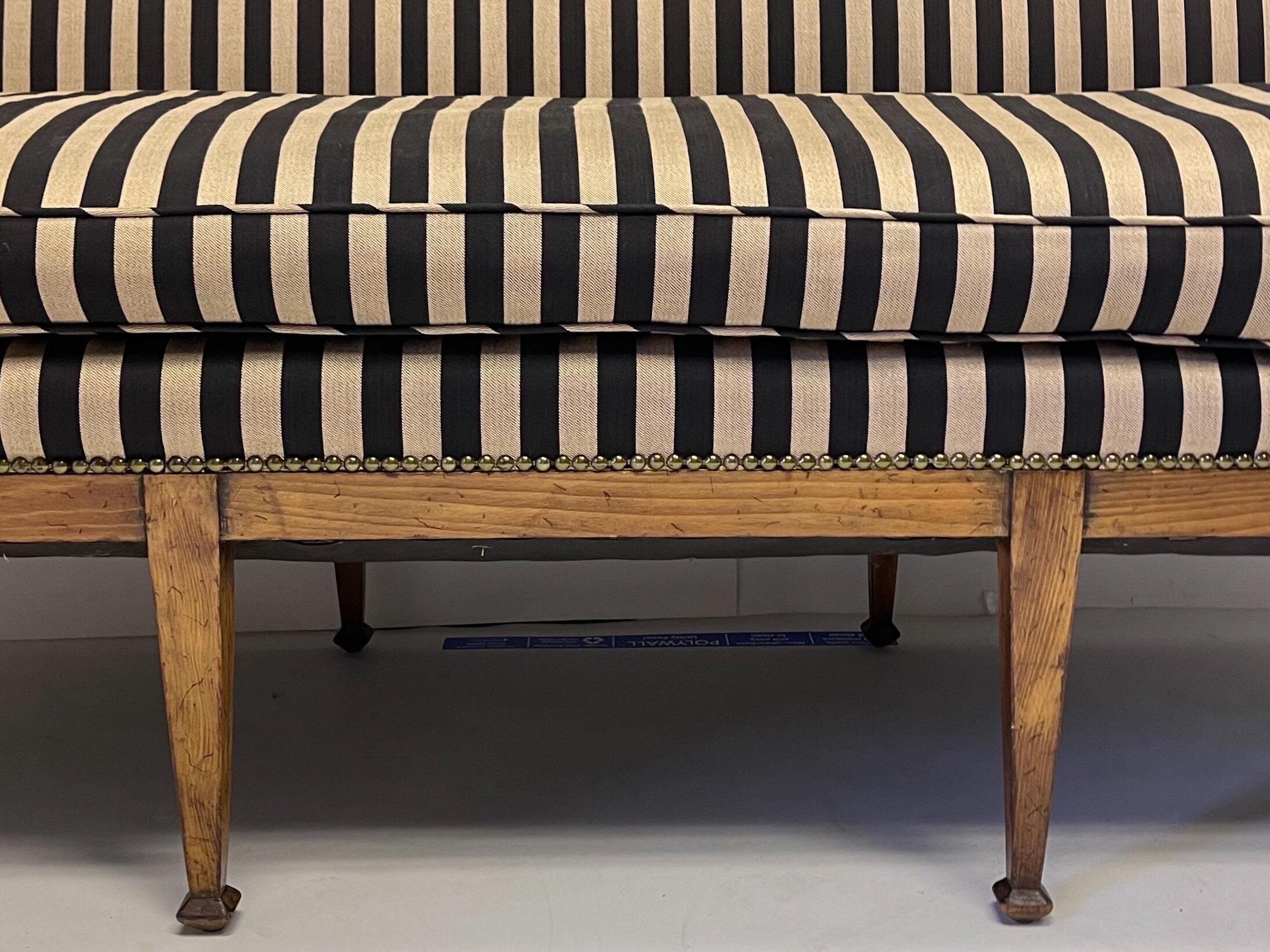 This is an early 20th century carved fruitwood Biedermeier style Italian sofa. The cushion is down, and the upholstery is vintage and shows lite wear. It is unmarked.