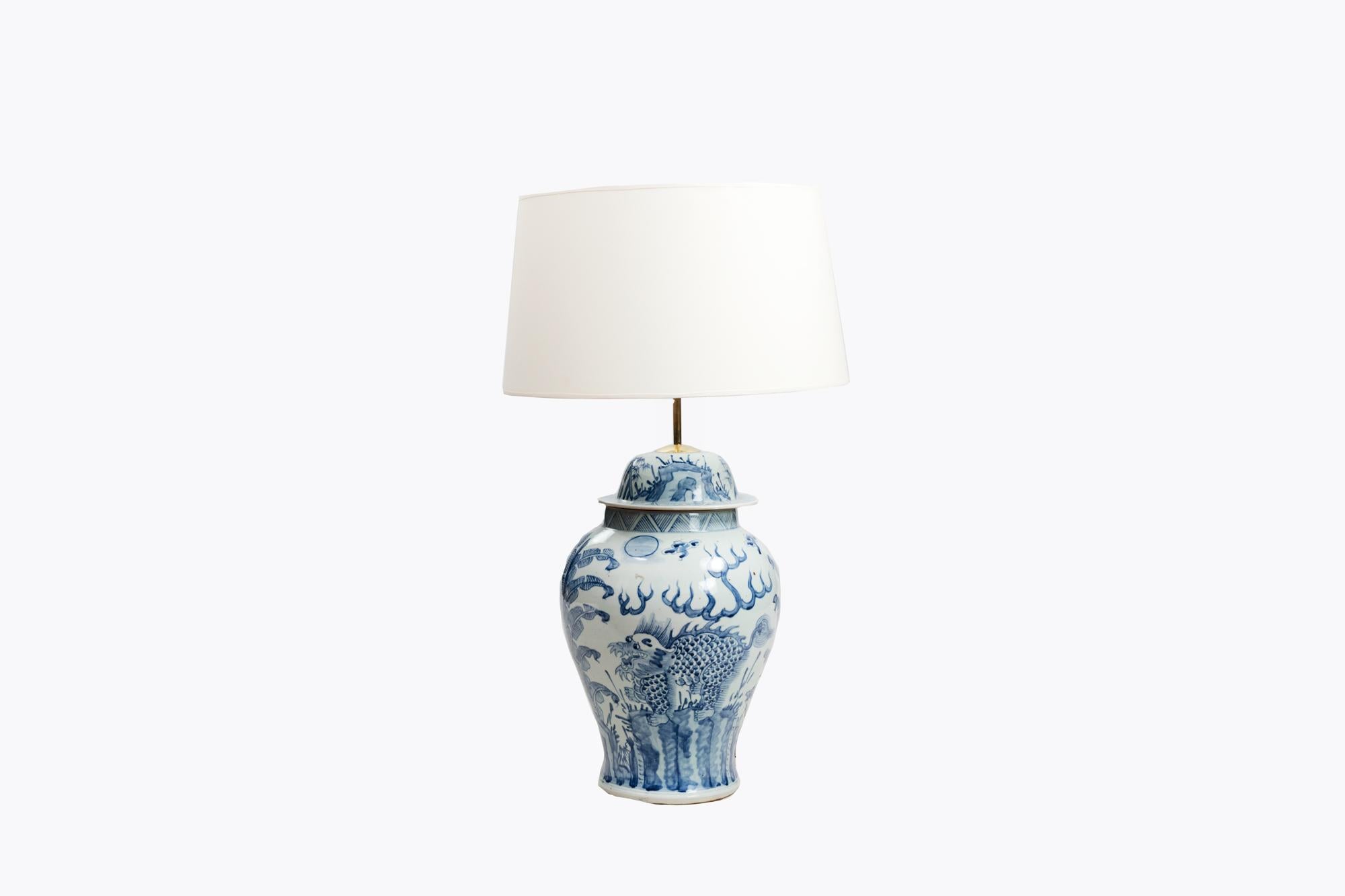 Early 20th Century blue and white ginger jar converted to lamp in the style of the Chinese period of the 18th Century. Ornamented with a floral landscape of leaves, and geometric motifs.