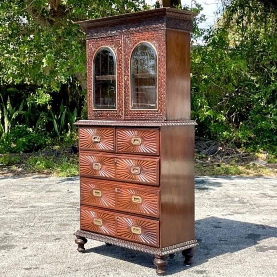 Elevate your home decor with this vintage Boho Anglo Indian carved sunburst cabinet, blending intricate craftsmanship with American flair. Add a touch of exotic charm to any room while embracing classic style and functionality.