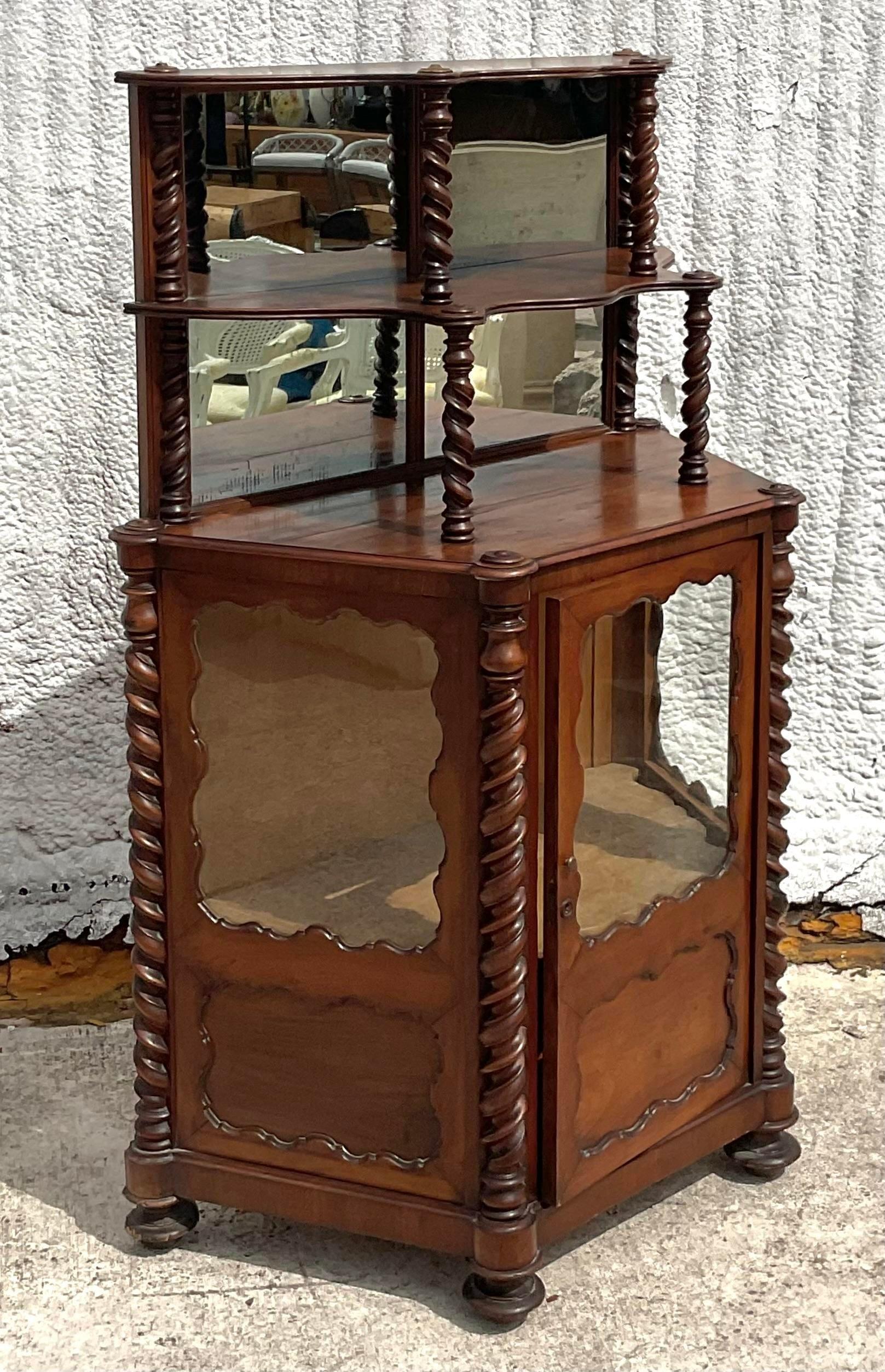 Embrace the allure of vintage Americana with this exquisite barley twist bi-level cabinet. Crafted with meticulous attention to detail, this piece captures the essence of boho charm and timeless sophistication. Its unique design features intricate