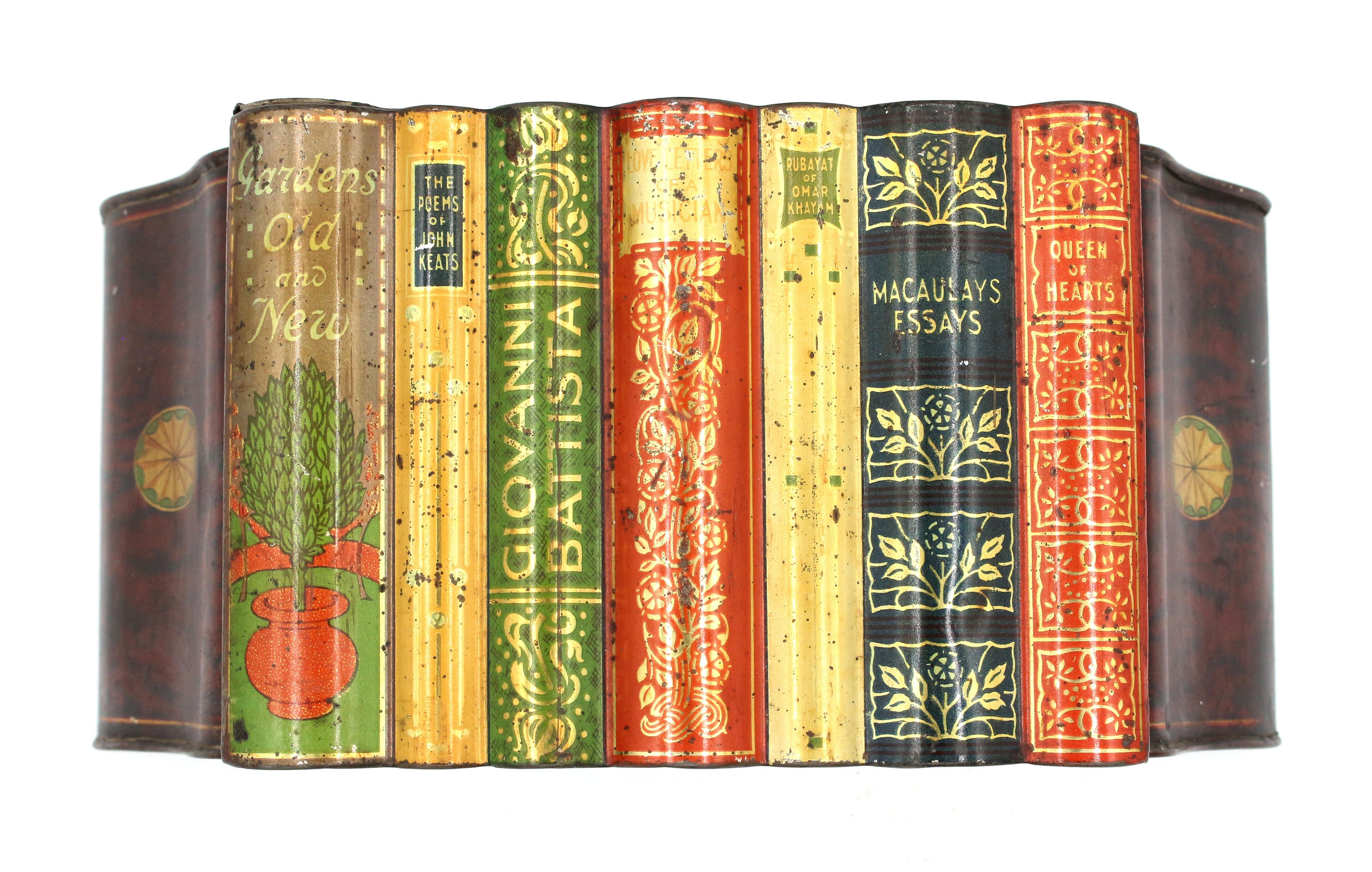 Boîte en fer blanc en forme de livre et de serre-livres par Huntley & Palmer, début du 20e siècle, Anglais. Faux rayonnage de livres entre des serre-livres en faux acajou et incrustation de paterae. Divers titres de livres bien décorés avec de la