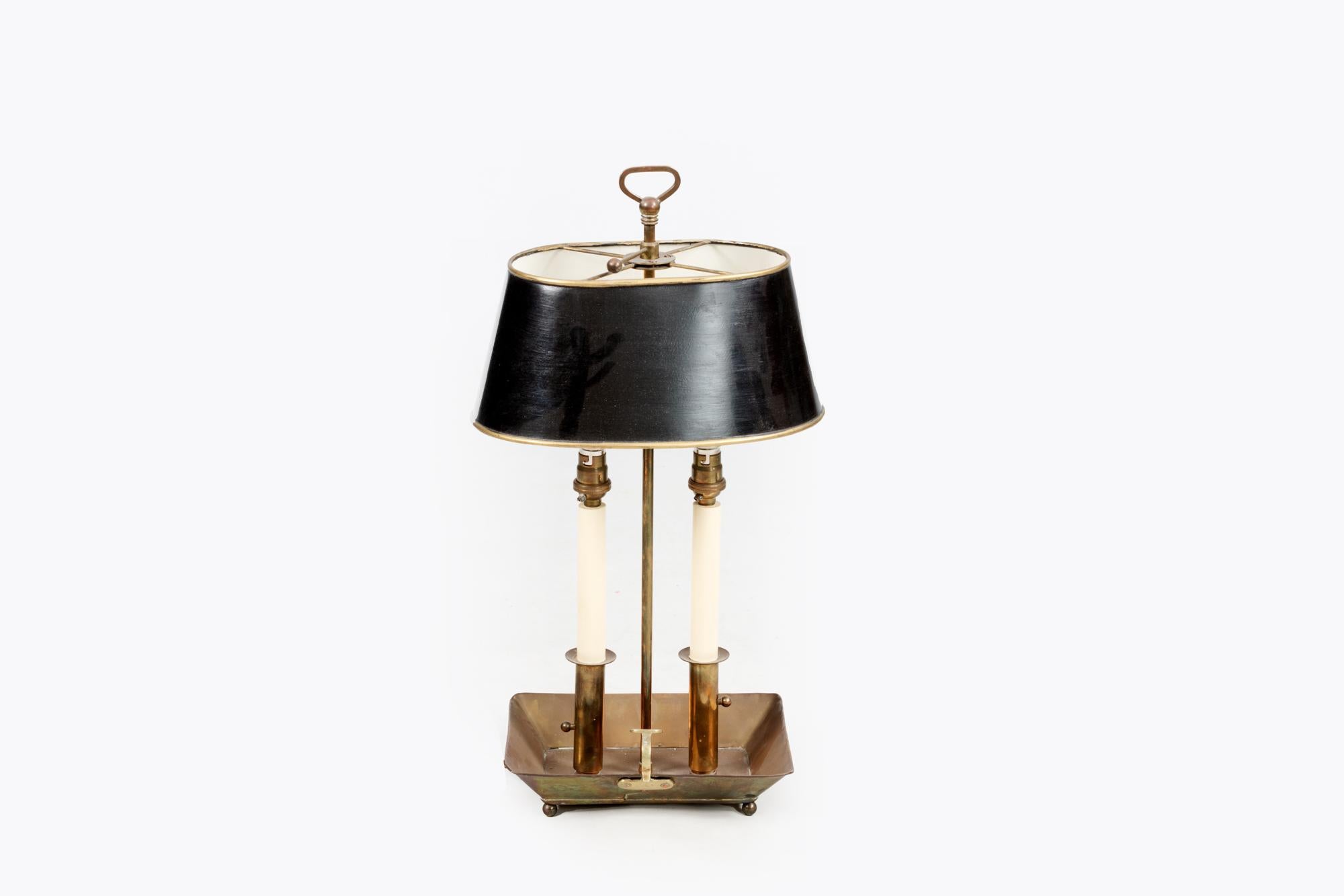 Early 20th century Bouillotte lamp in the French Empire style, the brass key raised above tole shade supported over two arms terminating on brass dish base of rectangular form.