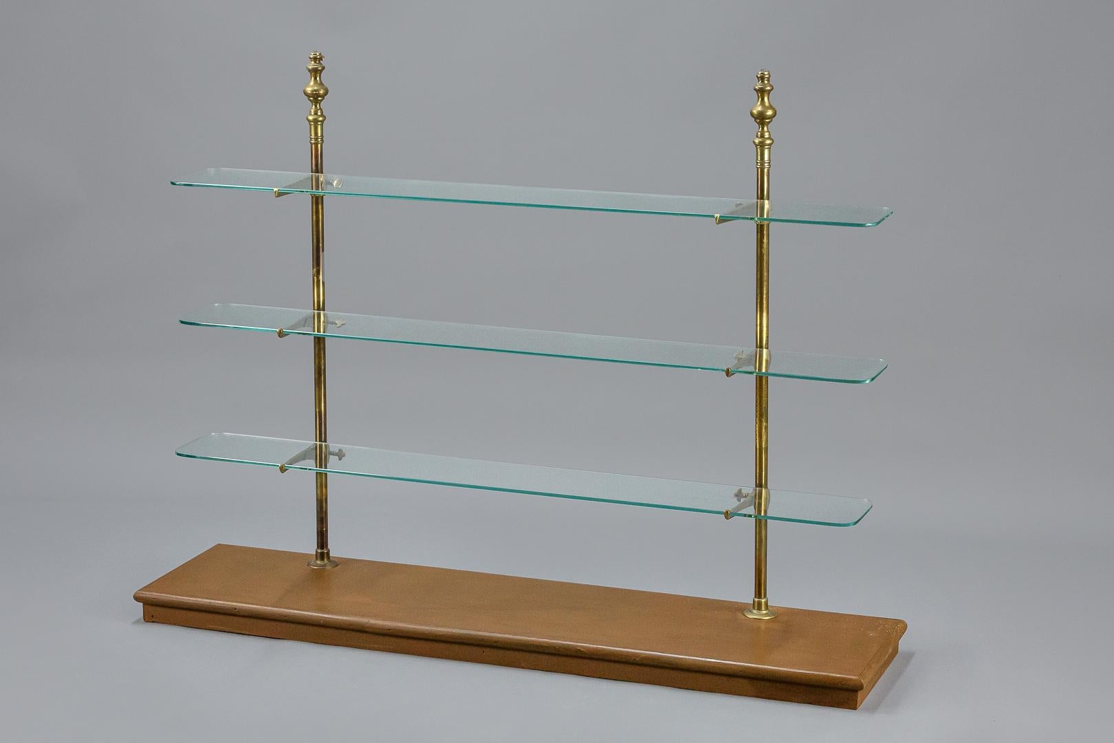 Brass and glass retail shop display shelving, mounted on a later wooden painted base, glass all present with no damage, later fixing points added to the top of each brass pillar. France circa 1920 and later (base)
Dimensions: 130cm x 100cm x 33cm.