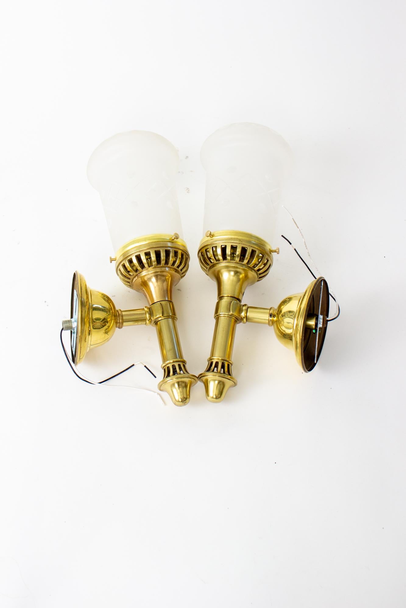 Early 20th Century brass sconces with cut glass shades. In the shape of an argand lamp, but was likely originally electric. Frosted and cut glass shades. C. 1910 American. Polished brass metals. Rewired and ready for installation in the US. Glass is