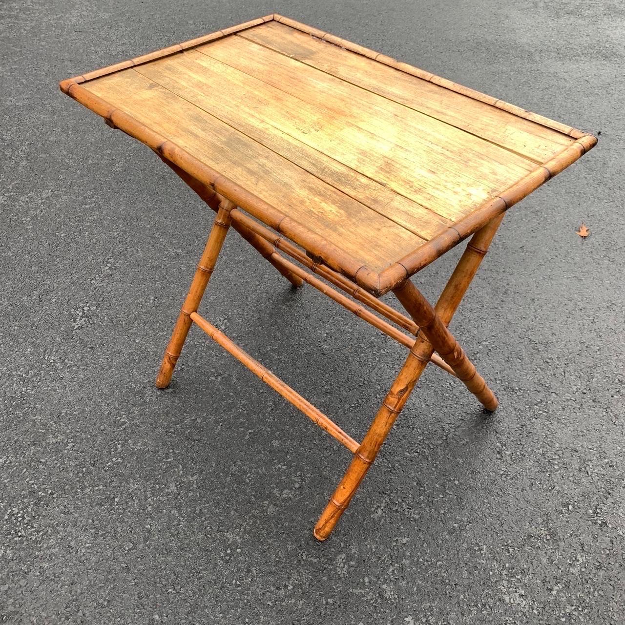 Table d'appoint ou de maître d'hôtel classique en bois de bambou. On voit cette table en bambou rabattable utilisée comme bar pour accueillir des bouteilles de vin ou d'alcool dans une salle à manger ou un salon. Peut également servir de table