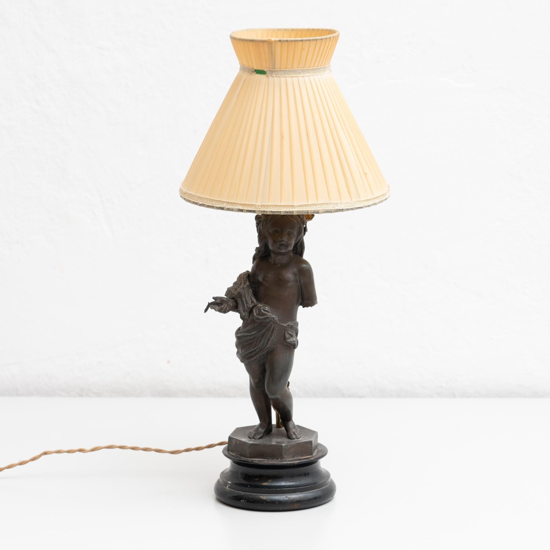 Early 20th century table lamp, with a beautiful decoration of a boy and a paper screen.

Manufactured by unknown designer in Spain.

In original condition, with minor wear consistent with age and use, preserving a beautiful