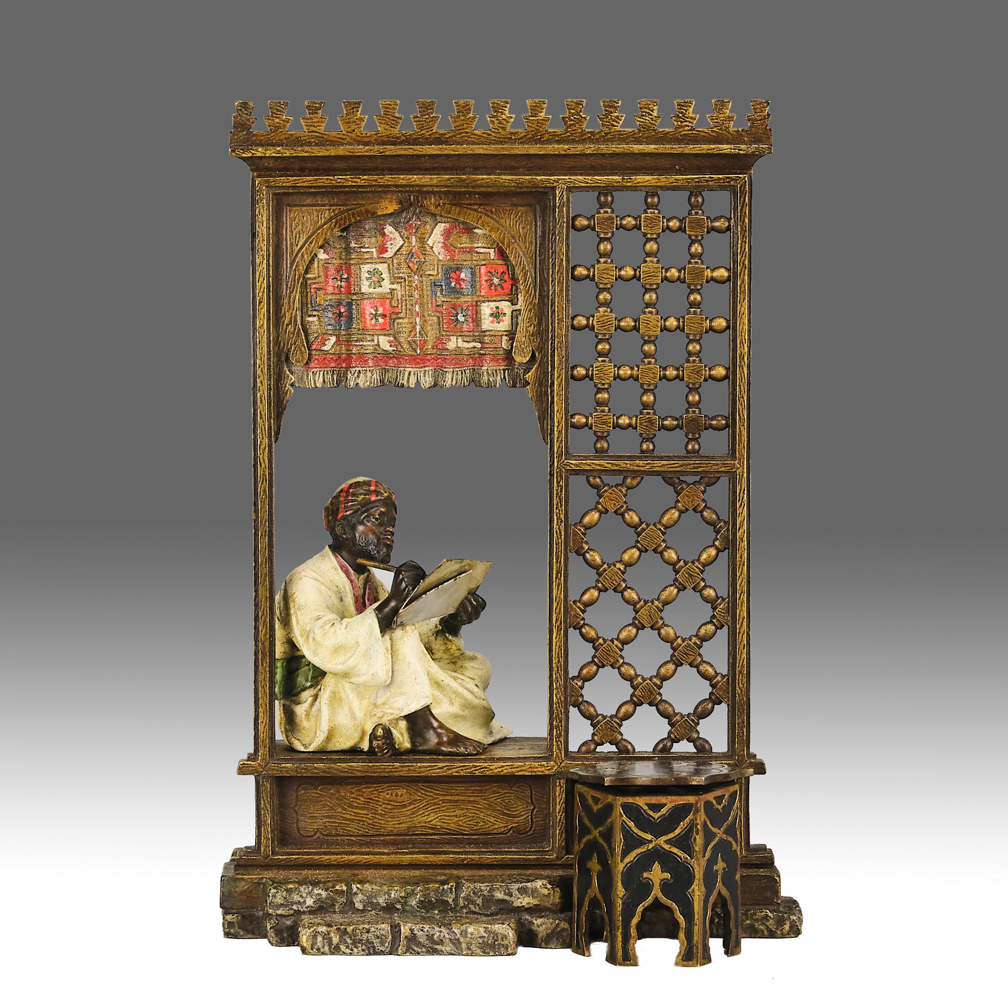 Excellente figurine autrichienne en bronze représentant un homme arabe assis dans une fenêtre/porte architecturale, écrivant sur son parchemin avec une table orientaliste à charnière à l'avant. Le bronze présente d'excellentes couleurs peintes à