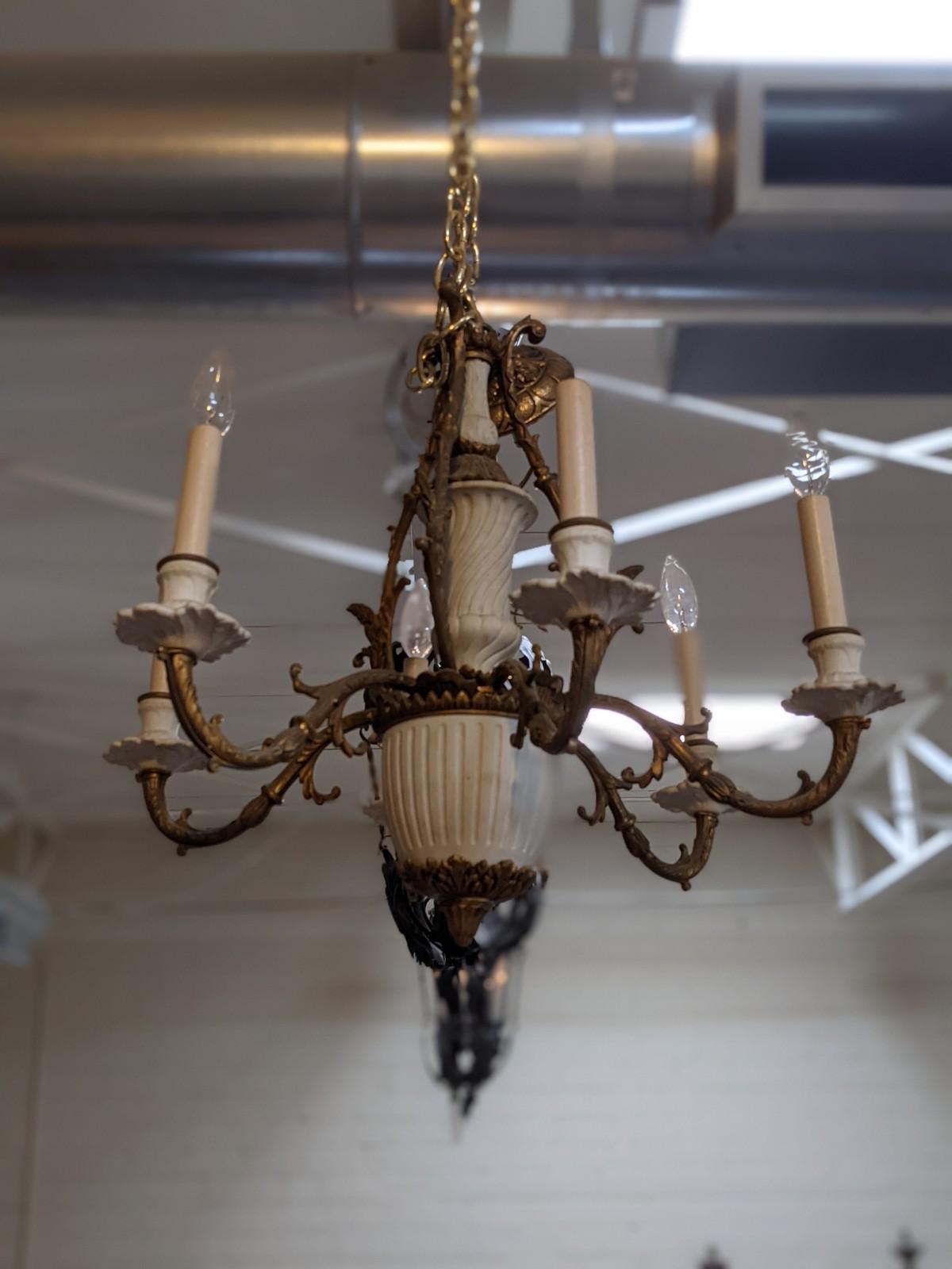 This bronze and ceramic chandelier origins from England, circa 1900.