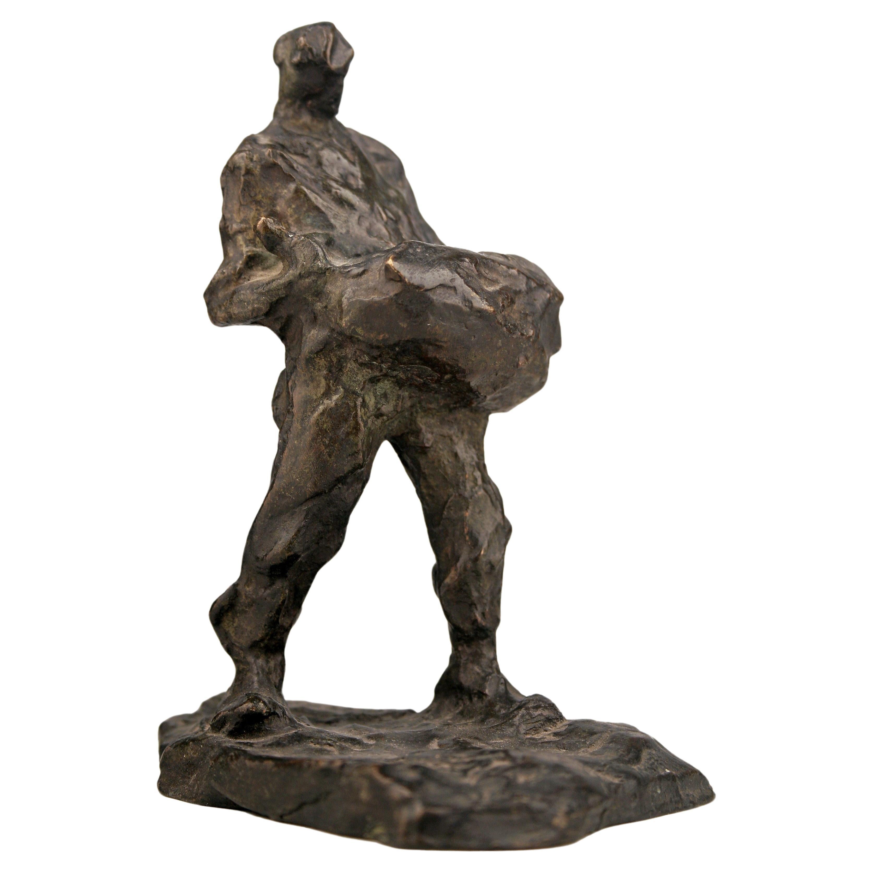 Sculpture en bronze du début du 20e siècle représentant un homme portant un sac à dos, réalisée par le sculpteur belge Demanet