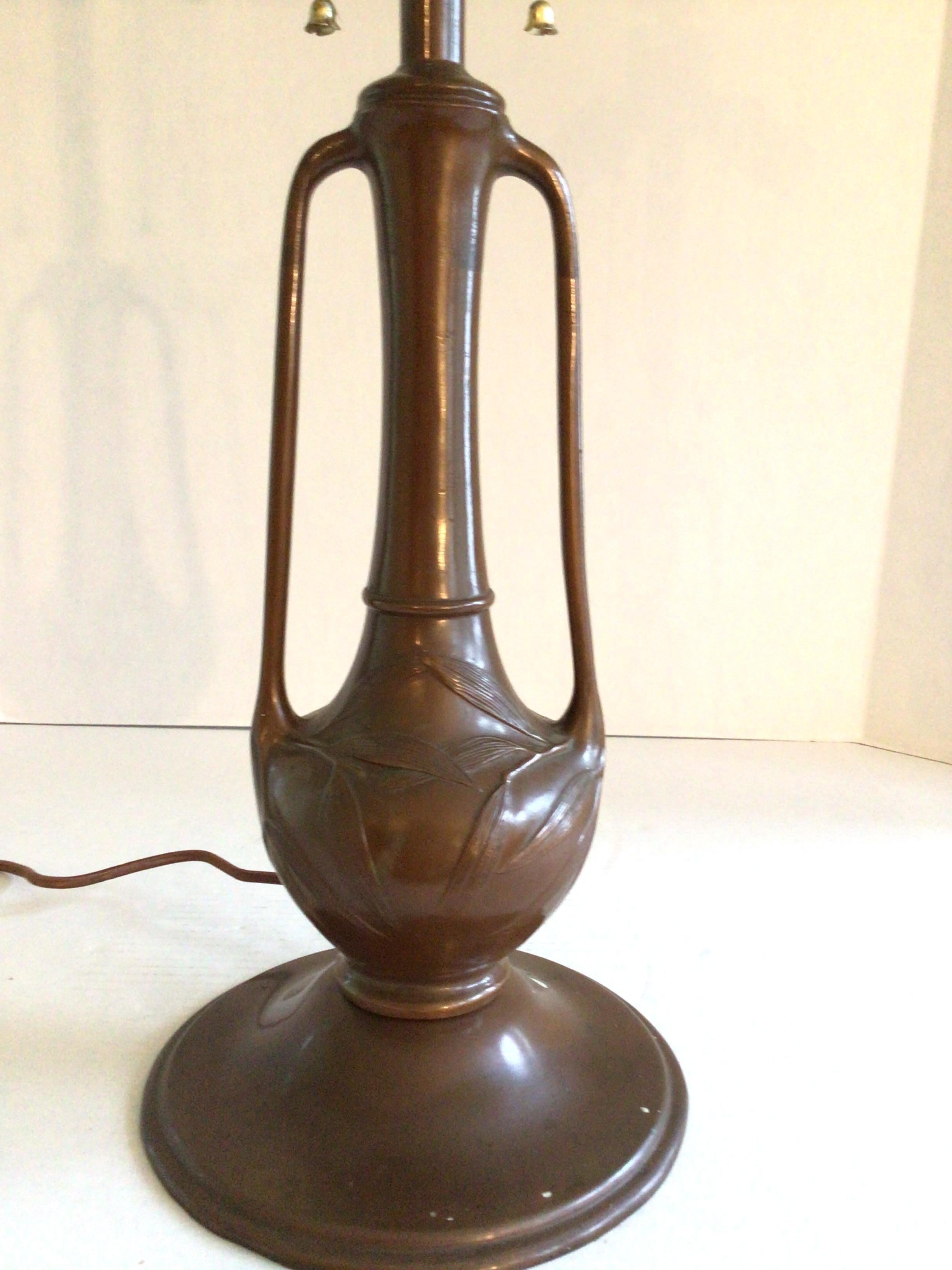 This early 2oth Century Pittsburg olive leaf table lamp was most likely made by Pittsburg Lamp, Brass and Glass Company of Pittsburg, PA, a manufacturer of fine molded lamps and lamp glass in business from 1901-1926. 
This lamp is cast metal in a