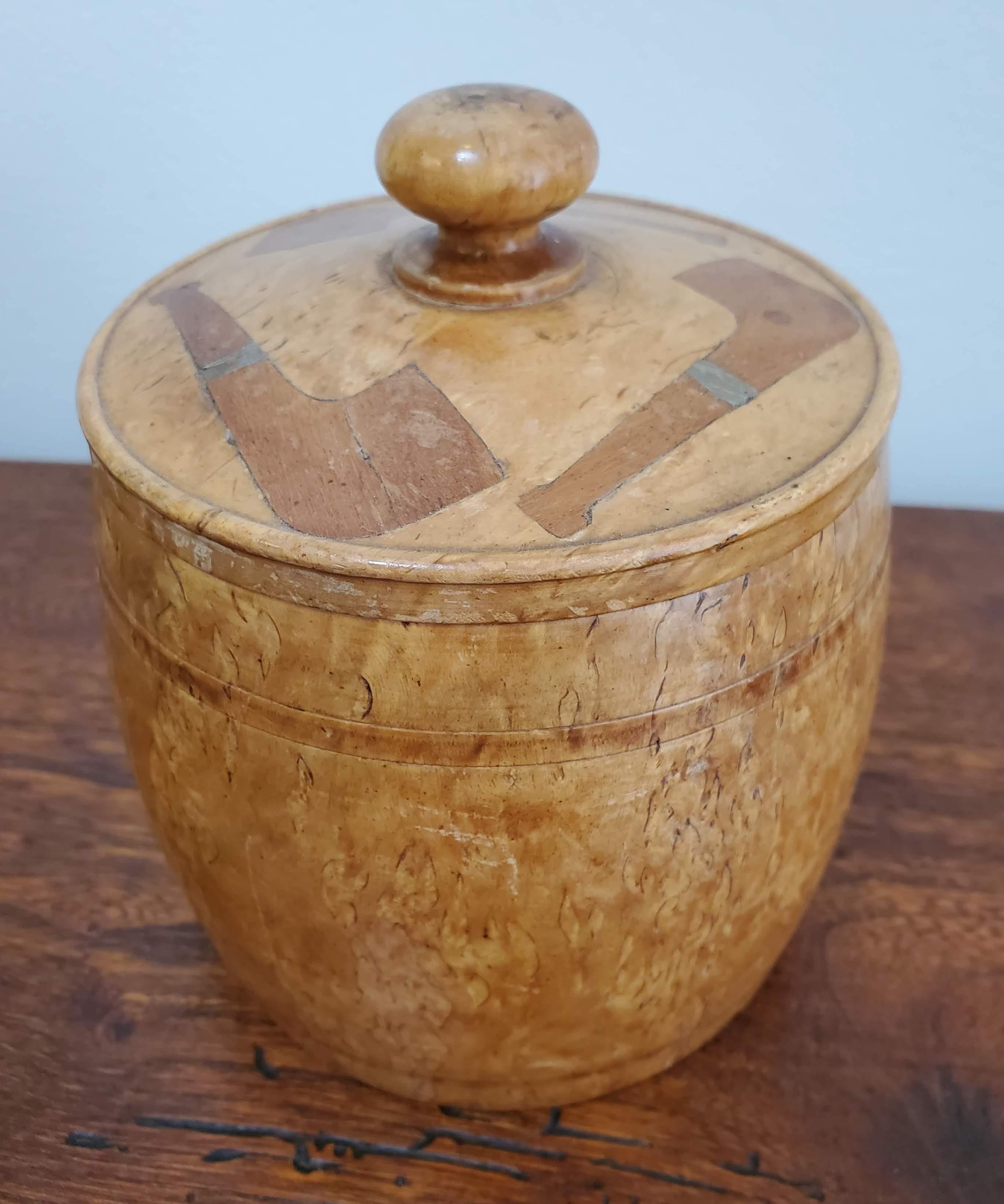 Smoking may be passé but collecting antique tobacco pieces is never bad for your health. This unique tobacco box in the shape of a barrel is made of highly figured burled birch wood with an inlay of mahogany and brass in the shape of pipes on the
