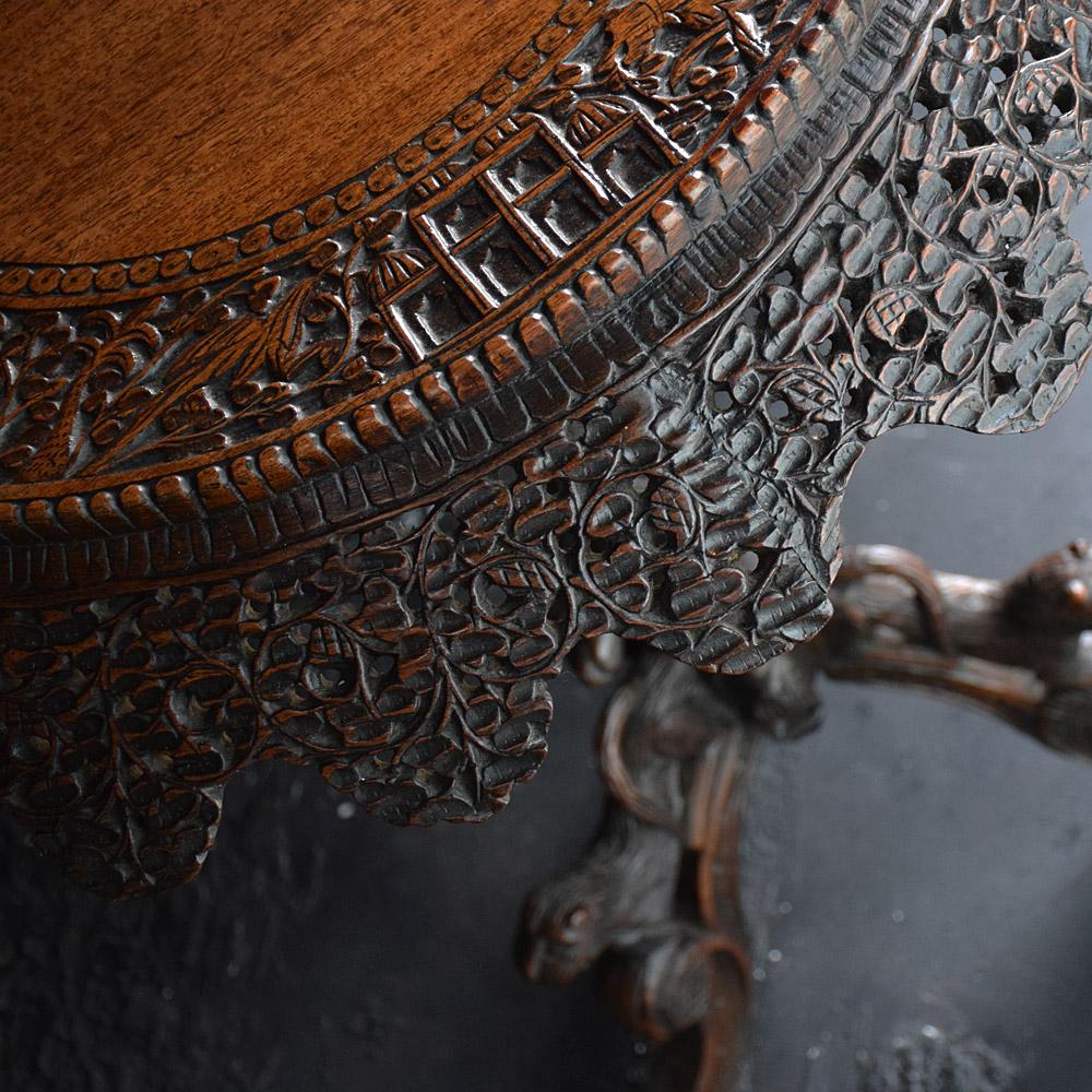 Early 20th century Burmese carved table.

An exceptionally well hand carved 19th century Burmese carved table, the top having a wonderfully carved frieze depicting temples, birds, animals, trees and various foliage, as if telling an ancient story,