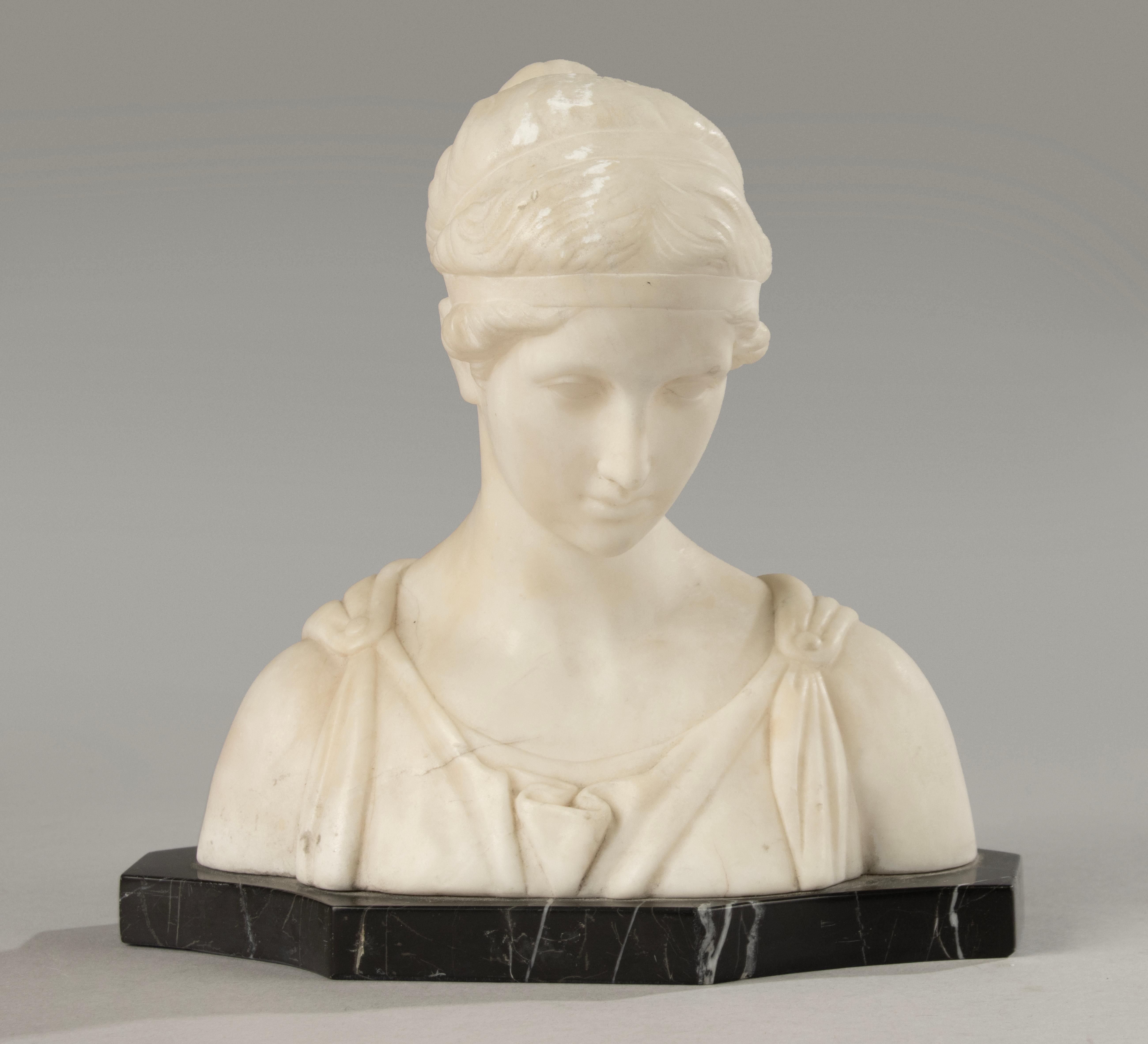 Este elegante busto neoclásico de mármol representa a Artemisa, también conocida como Diana, diosa de la luna, la castidad y la caza. Representada con expresión serena, peinado clásico con bandeau y vestimenta finamente drapeada, refleja la belleza