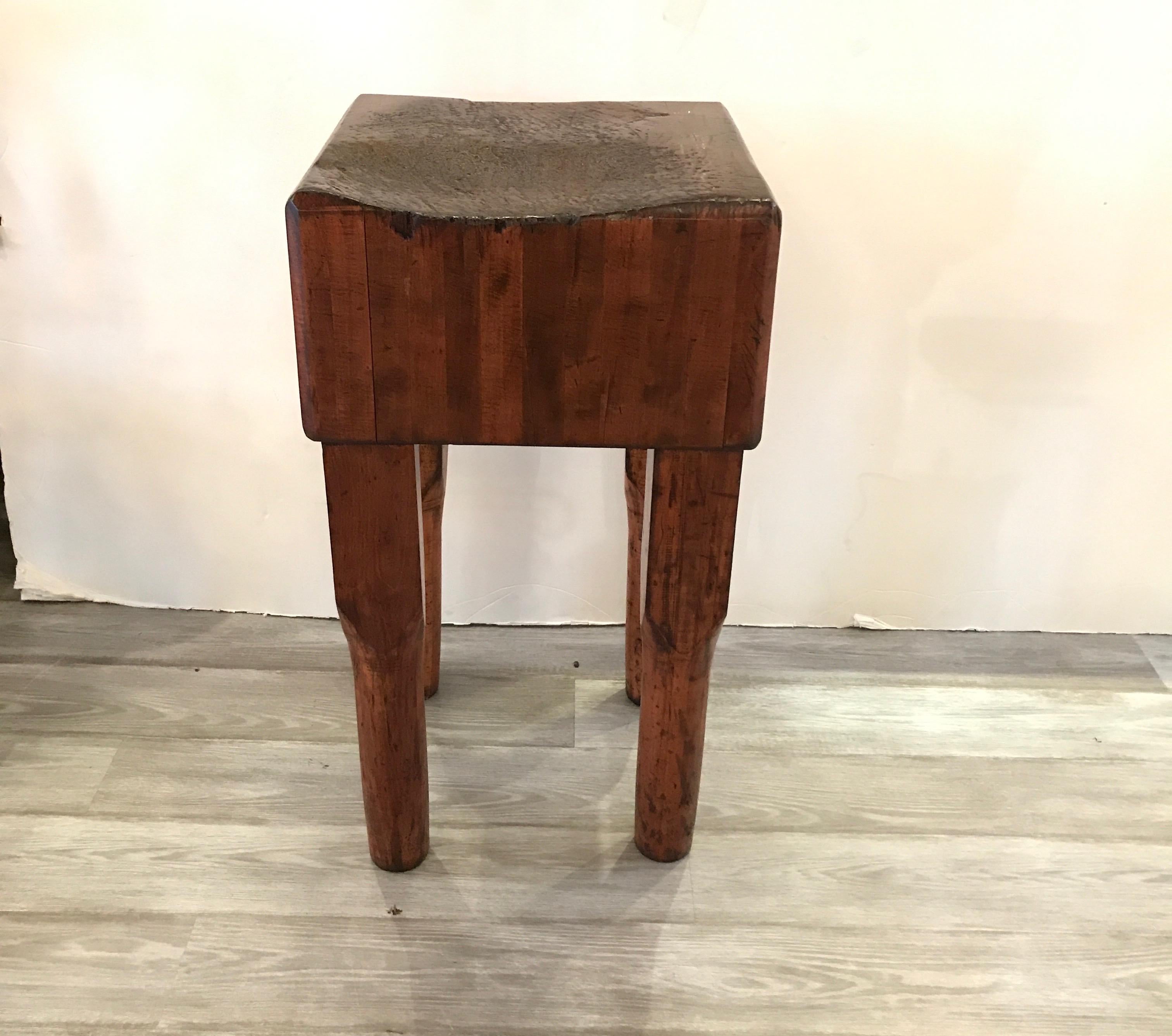 A perfectly sized chopping block of solid and well aged maple. The butchers workstation was well used and had been preserved with tits original patination with hollows and indentations from decades of use. The heavy thick top with sturdy legs,
