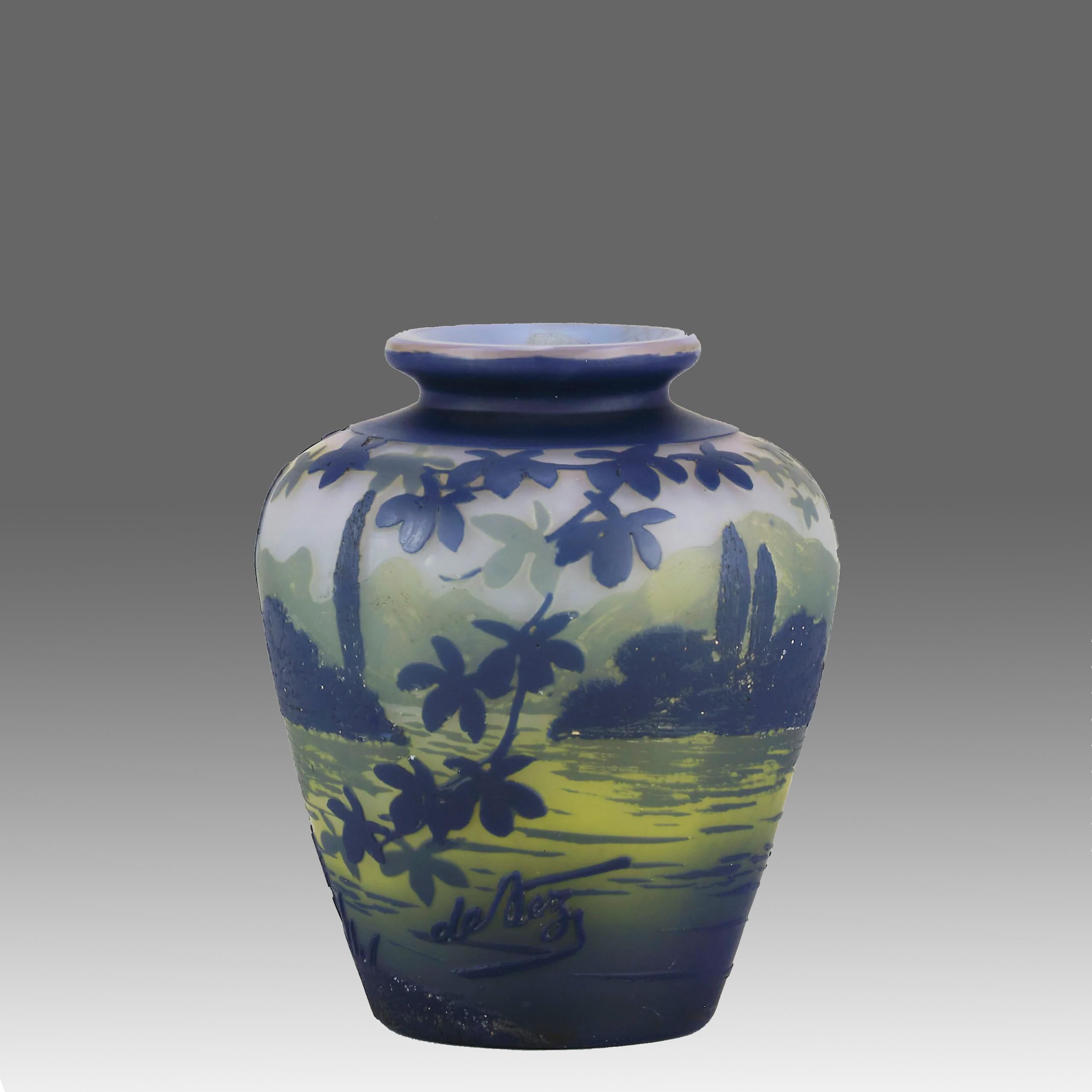 Un joli vase en verre camée du début du 20e siècle, taillé à l'acide et gravé à la main d'un paysage lacustre d'un bleu profond sur un champ vert avec un arrière-plan montagneux, présentant d'excellents détails finis à la main, signé De Vez.

