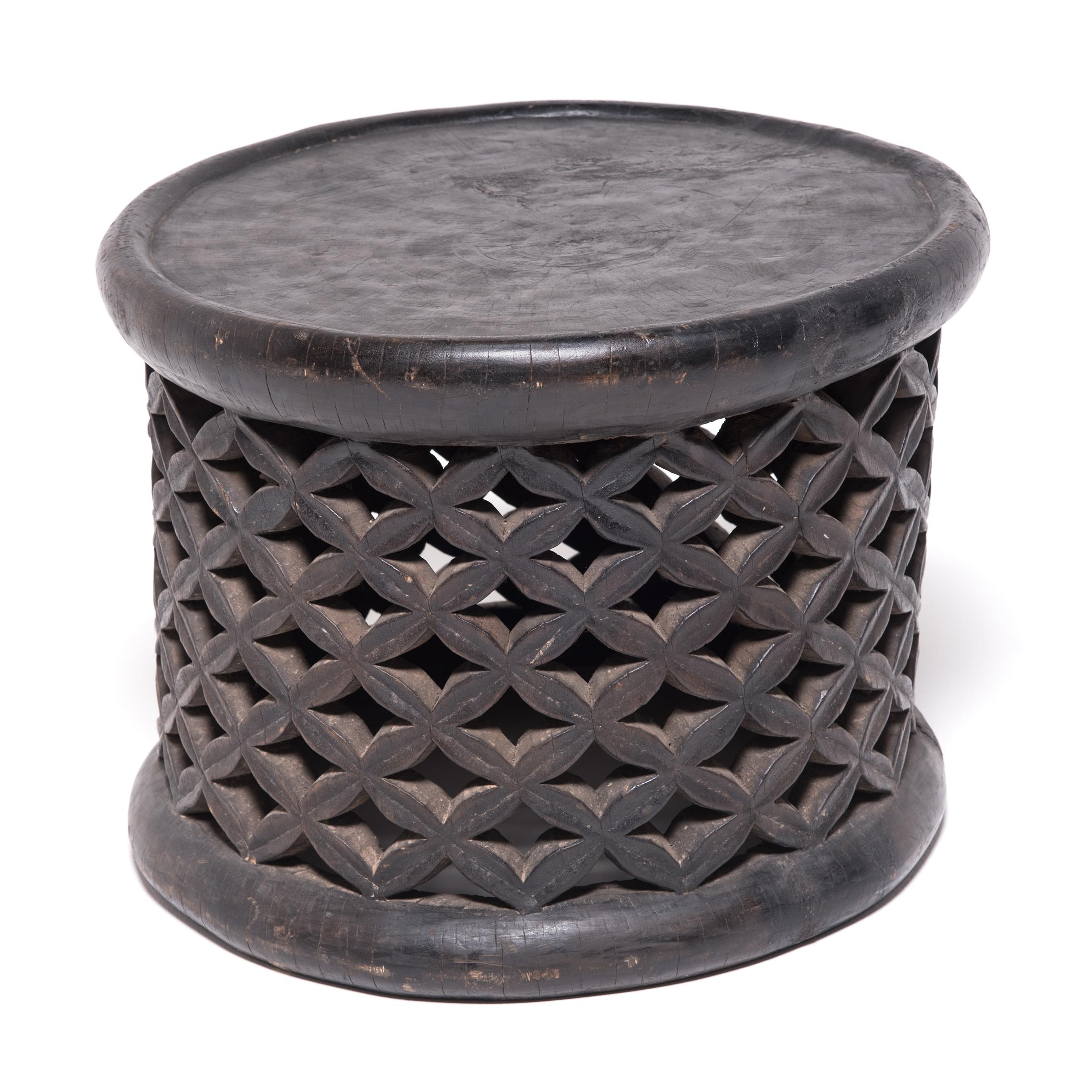 Carved from a single tree trunk, Bamileke lattice stools were used as symbolic seats in public ceremonies. The lattice webbing represents both the life cycle and the divine wisdom of the earth spider. A stool with broken lattice was immediately