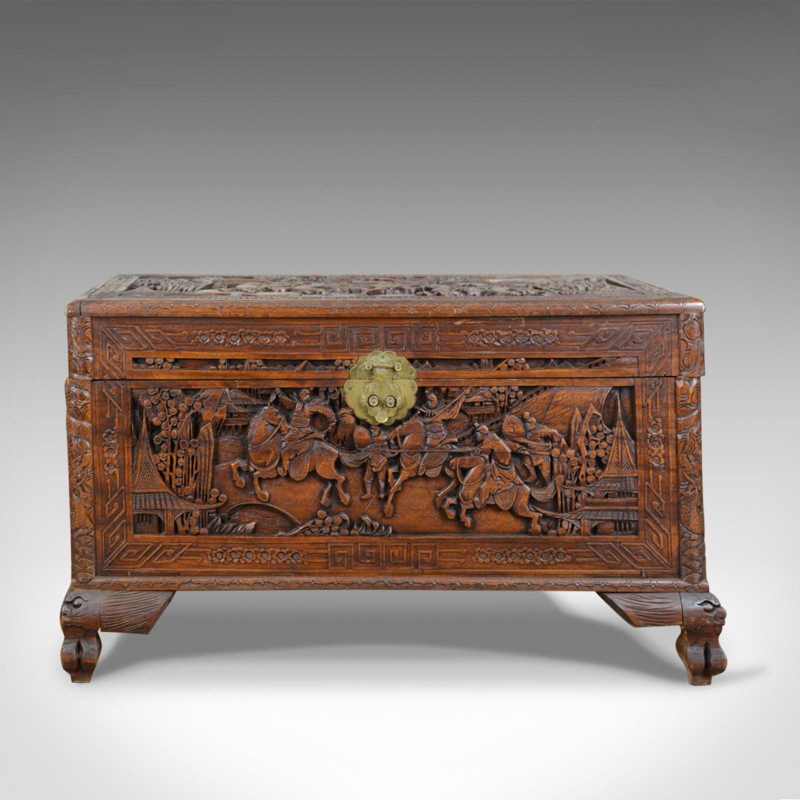 This is an early 20th century camphor wood chest with oriental carved scenes. A trunk dating to the early 20th century, circa 1930.

Fabulously decorated with profusely carved panels
Delineated with geometric frames and bands
Standing upon