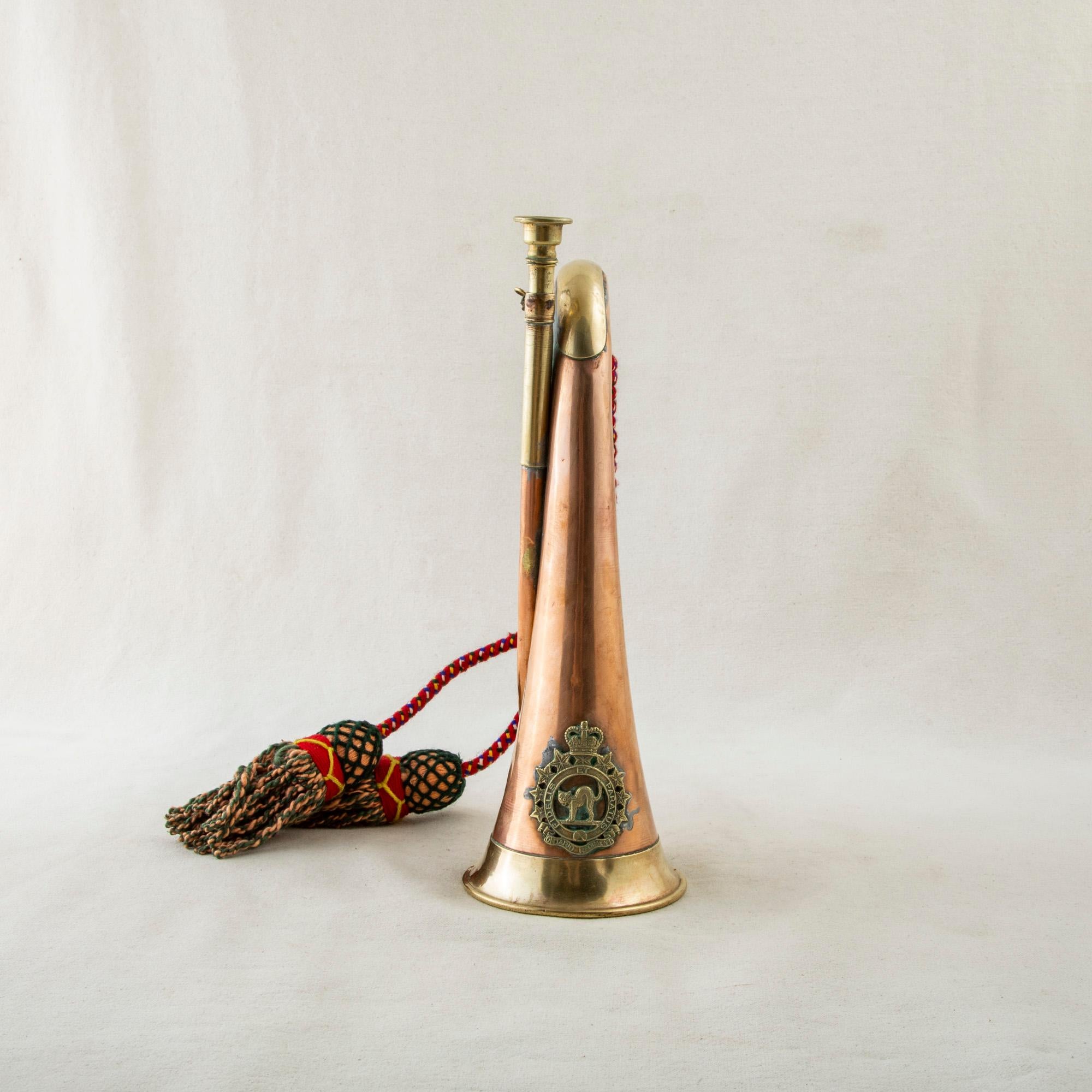 This early twentieth century copper and brass bugle features the bronze insignia for the Ontario Regiment with a cat in the middle and the surrounding Latin phrase Fidelis Et Paratus, or Faithful and Prepared, in English. The seal is topped with a