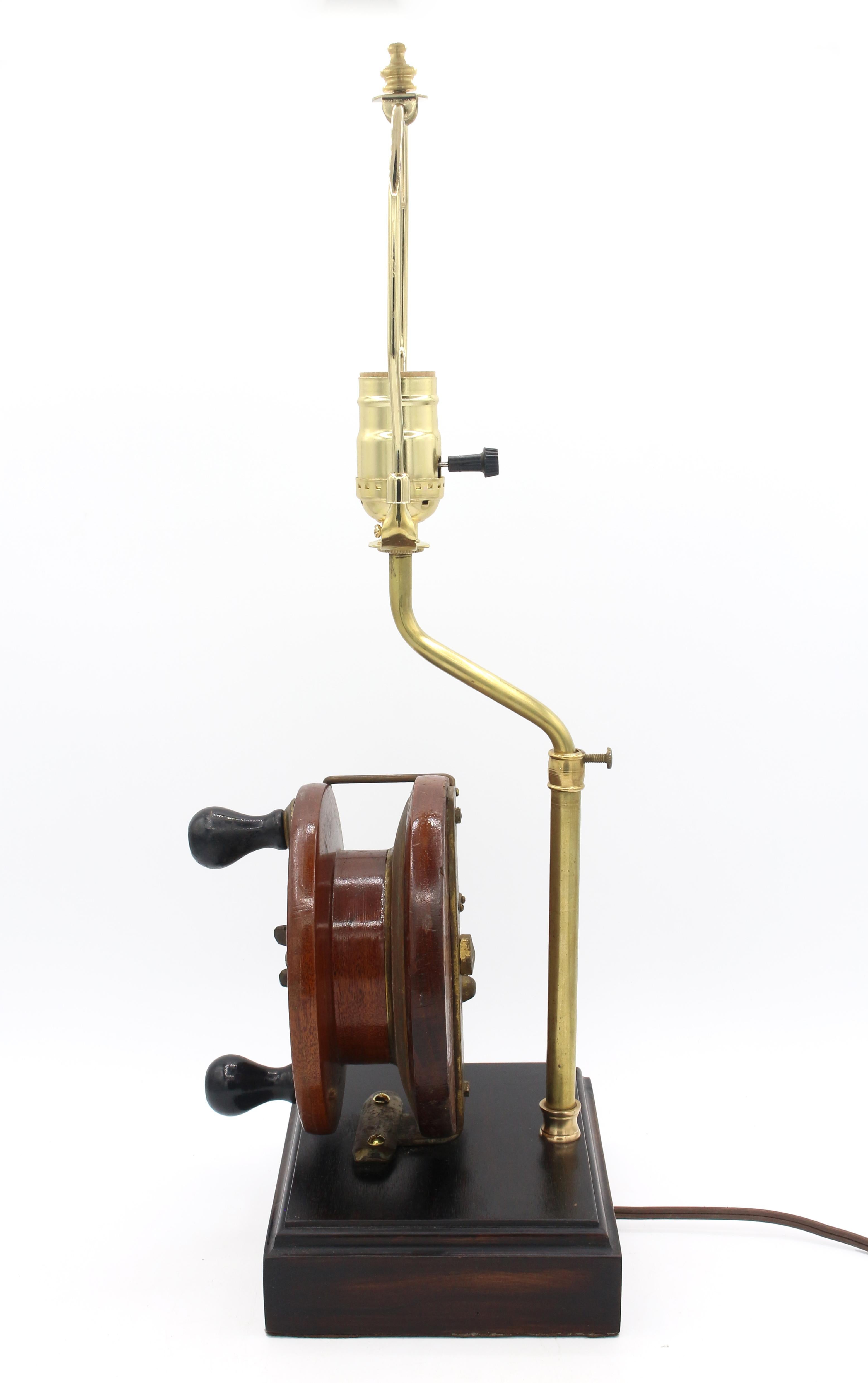 Early 20th century fishing reel now mounted as a lamp, Canadian. Mahogany. Label: Made by Peetz Tackle Limited Victoria, B.C., Canada. Now on a black African mahogany base to pick up on the ebony of the reel knobs. Brass trim.
6