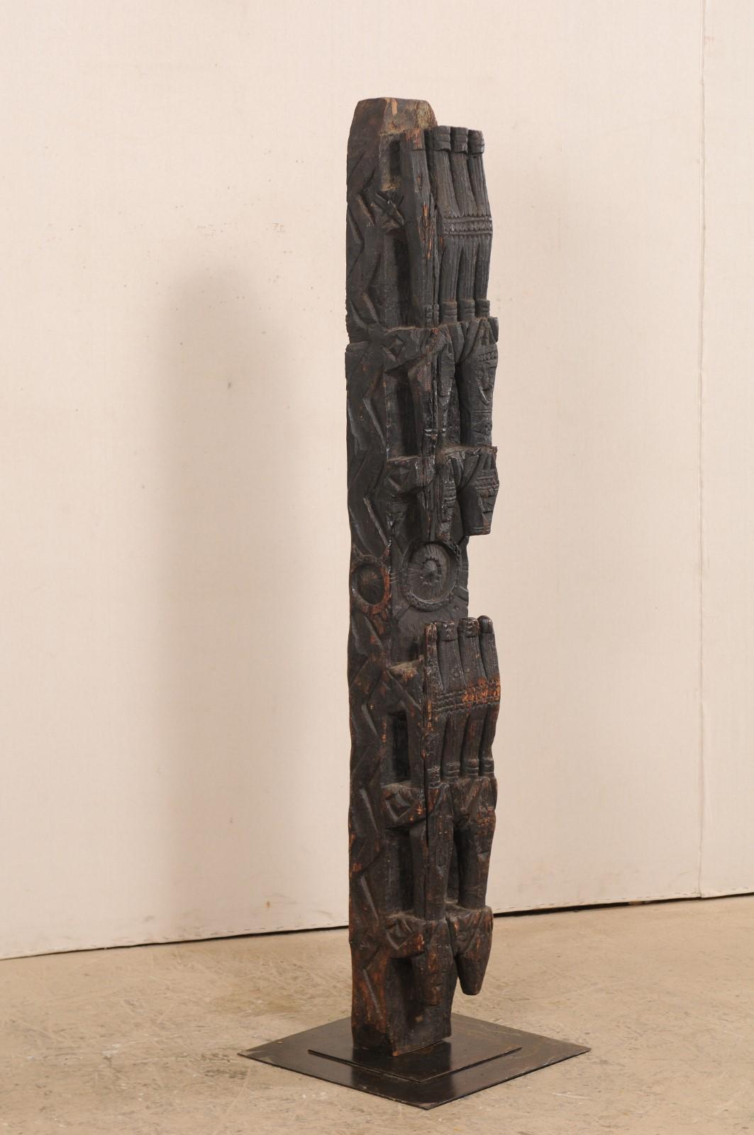 An early 20th century carved wood support beam from central Asia, custom mounted on iron stand. This antique wooden support beam was once a lintel which adorns the upper doorway of a central Asian home. It has been hand carved with three-dimensional