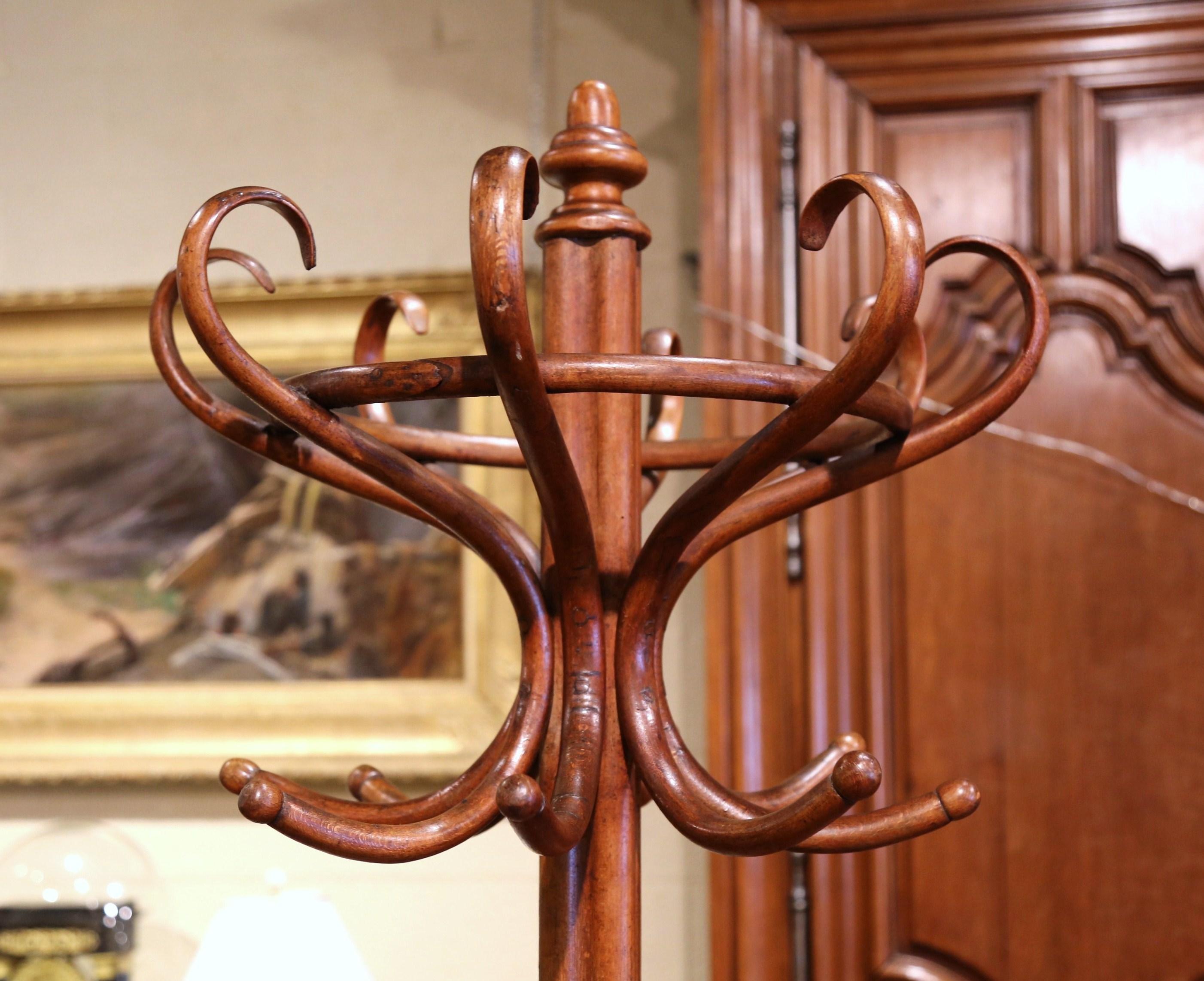 The elegant hat rack was crafted in France, circa 1930 in the style of German-Austrian cabinet maker, Michael Thonet (1796-1871). The hall tree features two rows of eight hooks each, so it could be used as a dual hat and coat rack. The tall rack