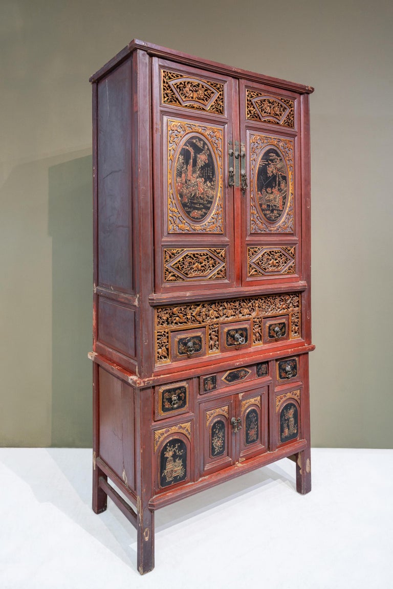 An early 20th century carved 2-tier cabinet from Fujian province, China. The carvings on the front are mostly through carvings, which are carved very deep and lively, featuring human characters as well as various animals. The oval panels on the top