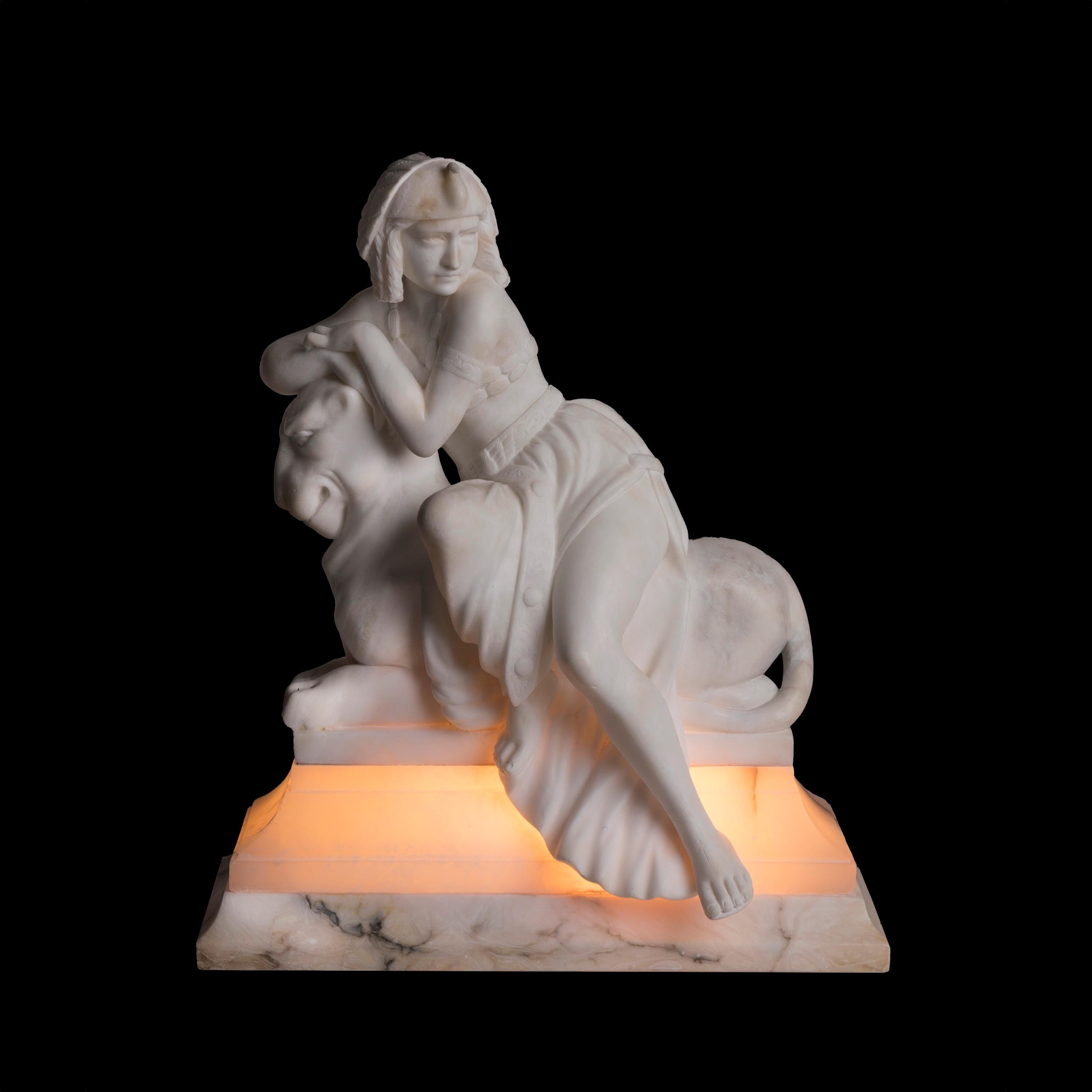 Lampada figurata in alabastro finemente intagliato
in stile revival egiziano

Realizzata in alabastro luminoso, la lampada da tavolo incarna lo stile Revival egiziano, modellato come una figura seduta di donna faraonica, graziosamente adagiata su un