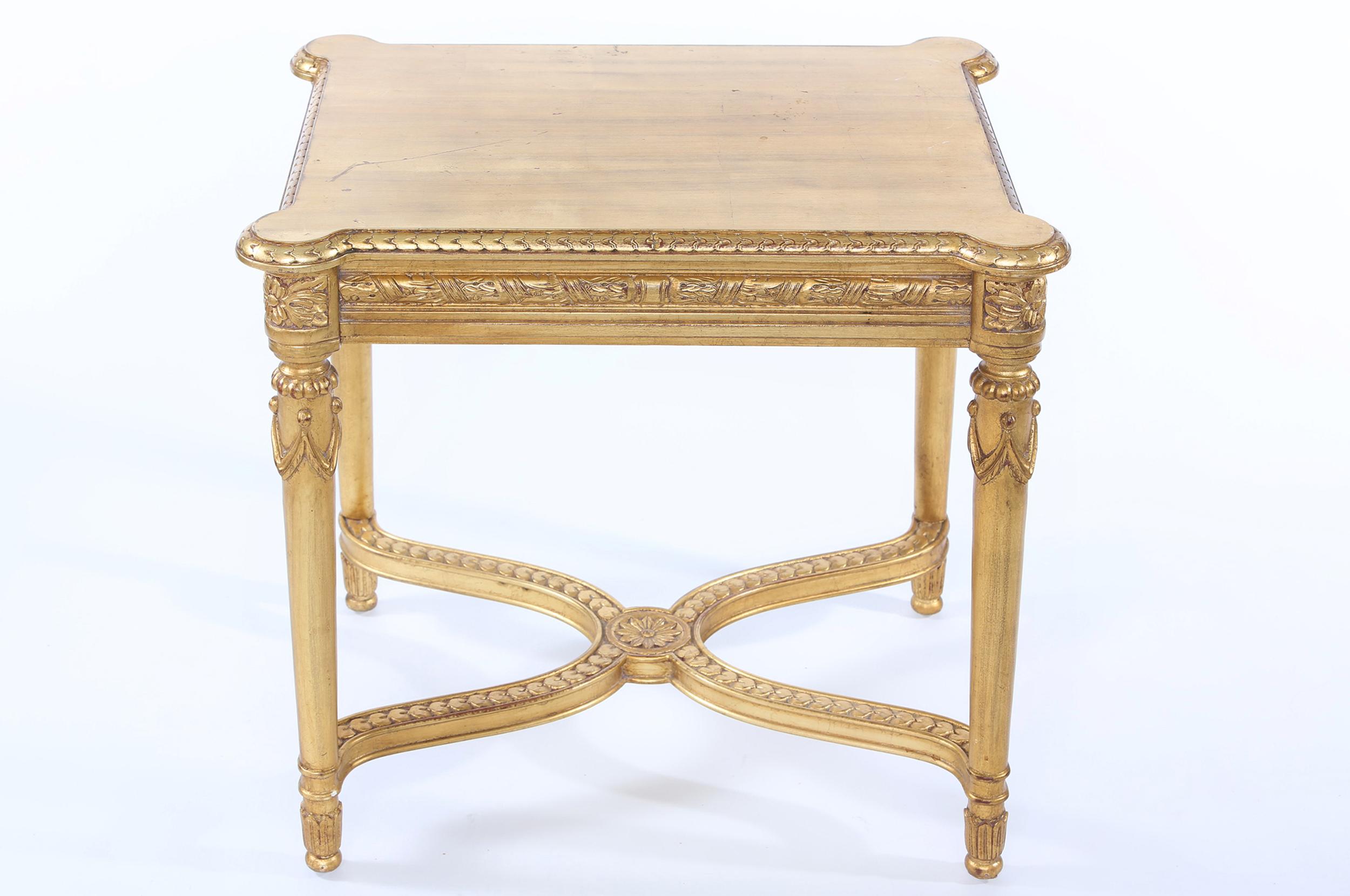 Early 20th century giltwood table with finely carved exterior base design details. The coffee / center table is in great condition. Minor wear consistent with age / use. The table stands about 19 inches high x 39 inches long x 21 inches