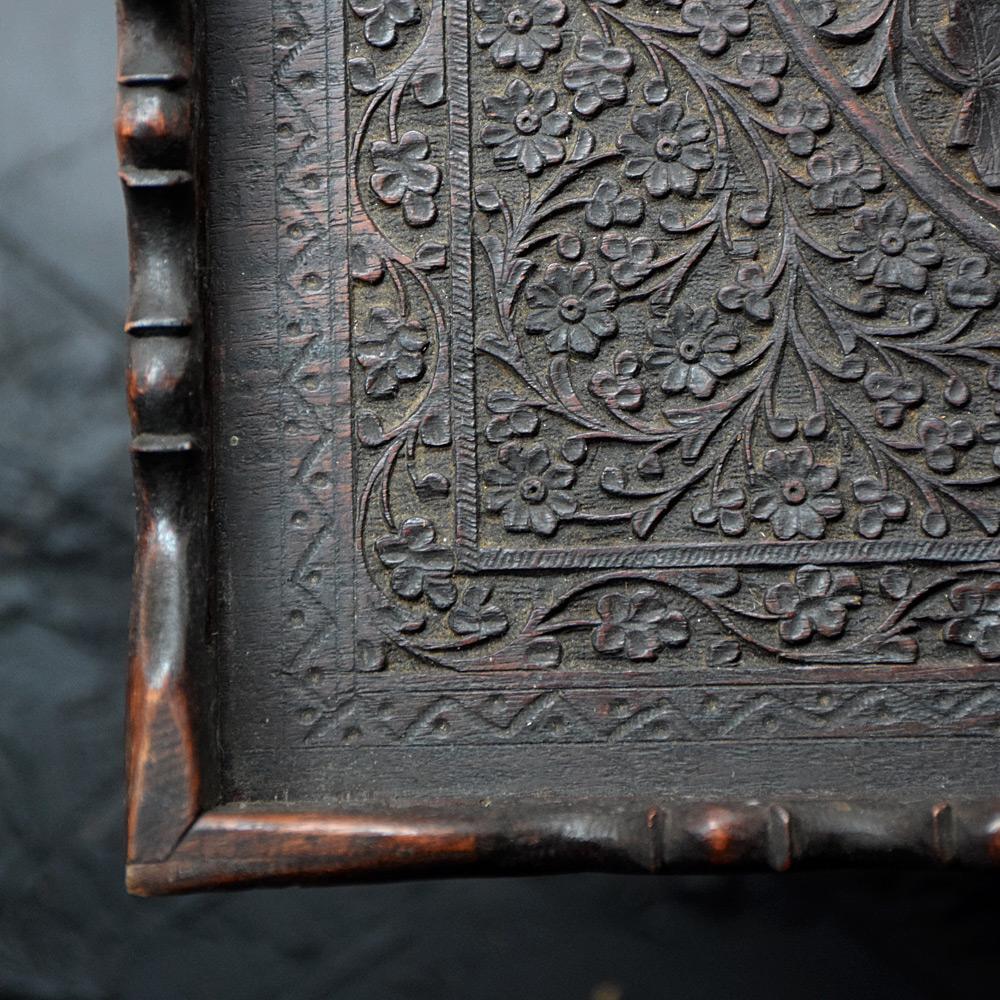 Early 20th century carved Indian occasional tray table 

Made from hand carved wood displaying some fine detail across all surfaces which include floral foliage. Stood on metal wheels, originally this item would have had a removable top tray and