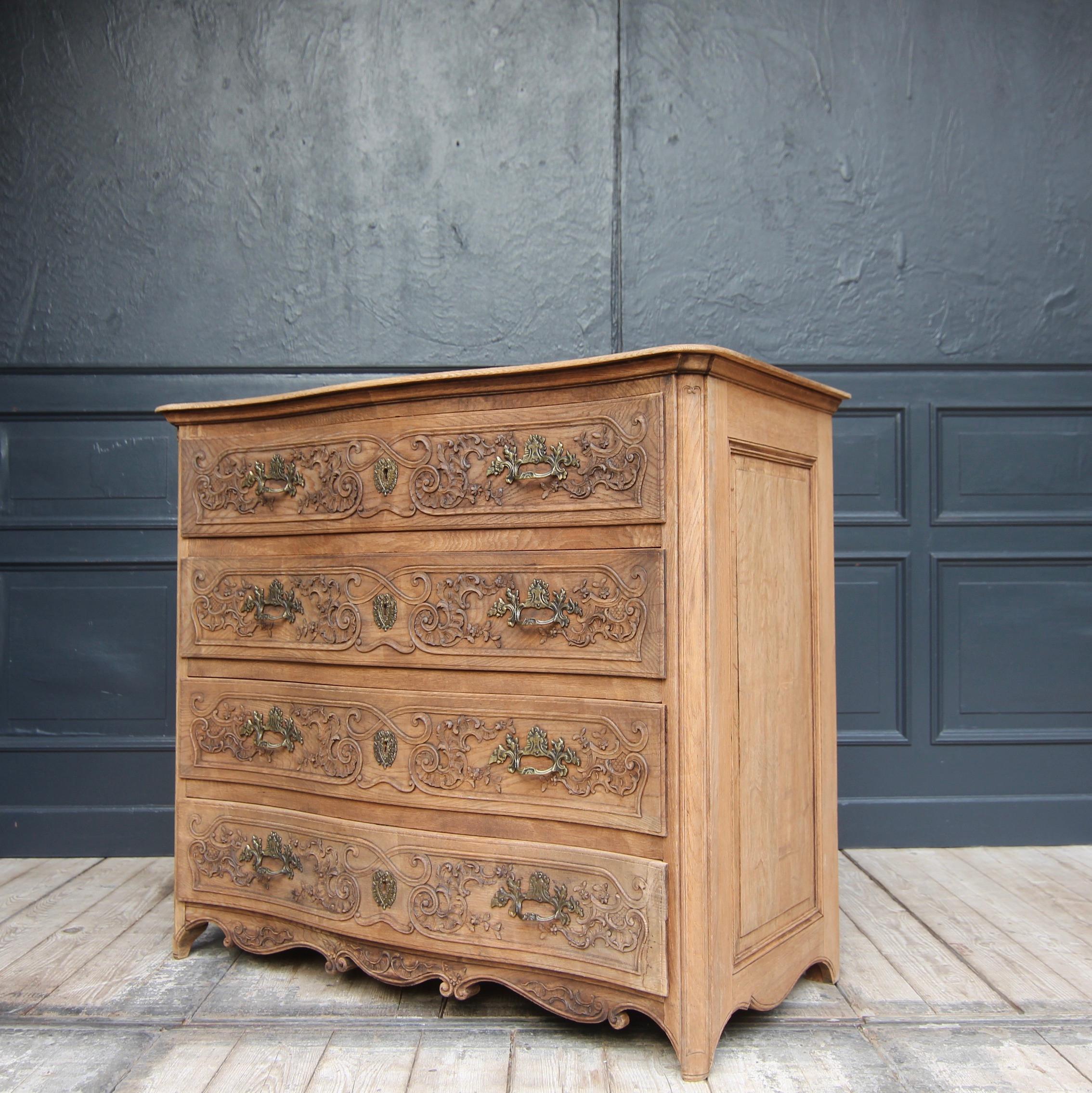 Elegant baroque style chest of drawers from the early 20th century. Made of solid oak wood and carved. 

Laterally coffered four-bay oak body with rounded corners and slightly curved front, as well as a matching moulded top panel and multiple curved
