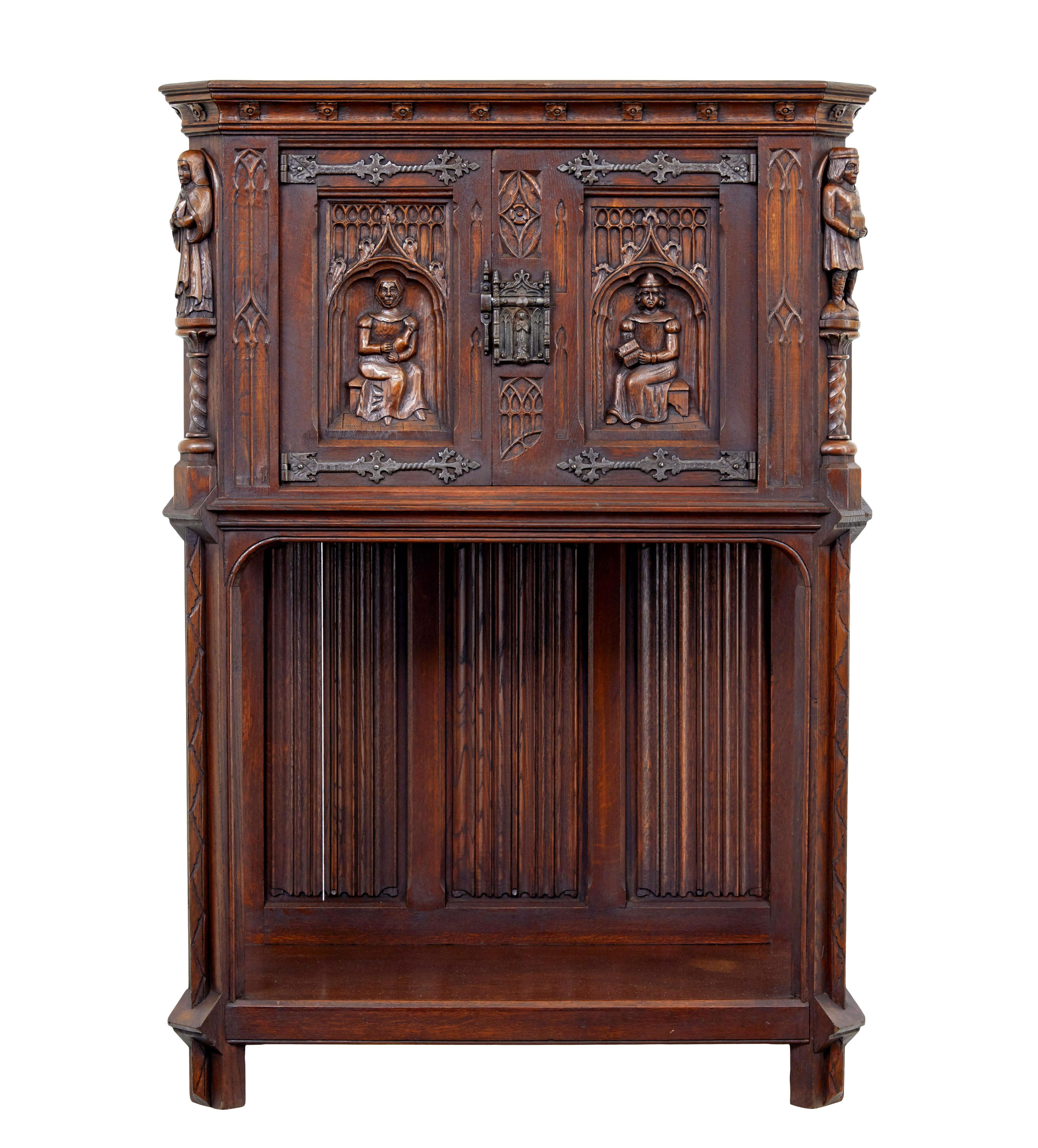 Early 20th century carved oak gothic revival cupboard circa 1900.

Good quality flemish neo renaissance cupboard.  Made in 1 piece, with the top forming a cupboard.  Decorated with hand carved figures in period clothing, flanked either side by