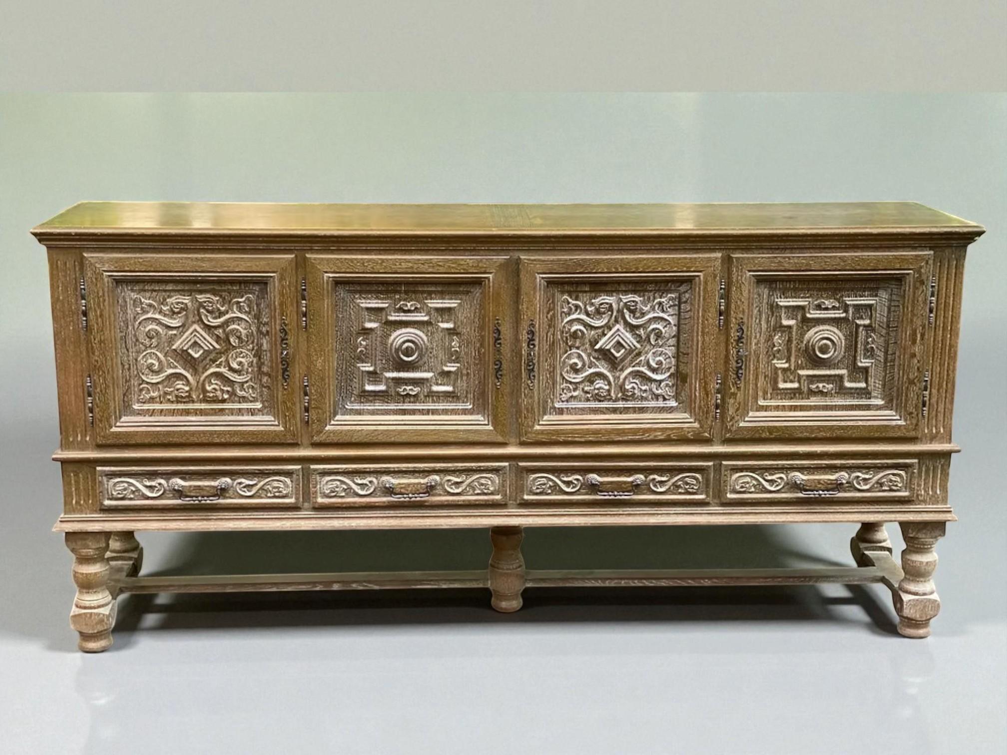 This monumental sideboard is a striking example of Spanish Renaissance Revival craftsmanship, showcasing intricate hand-carved ornamentation and a commanding architectural presence. Made from solid oak with a softly weathered finish, the piece