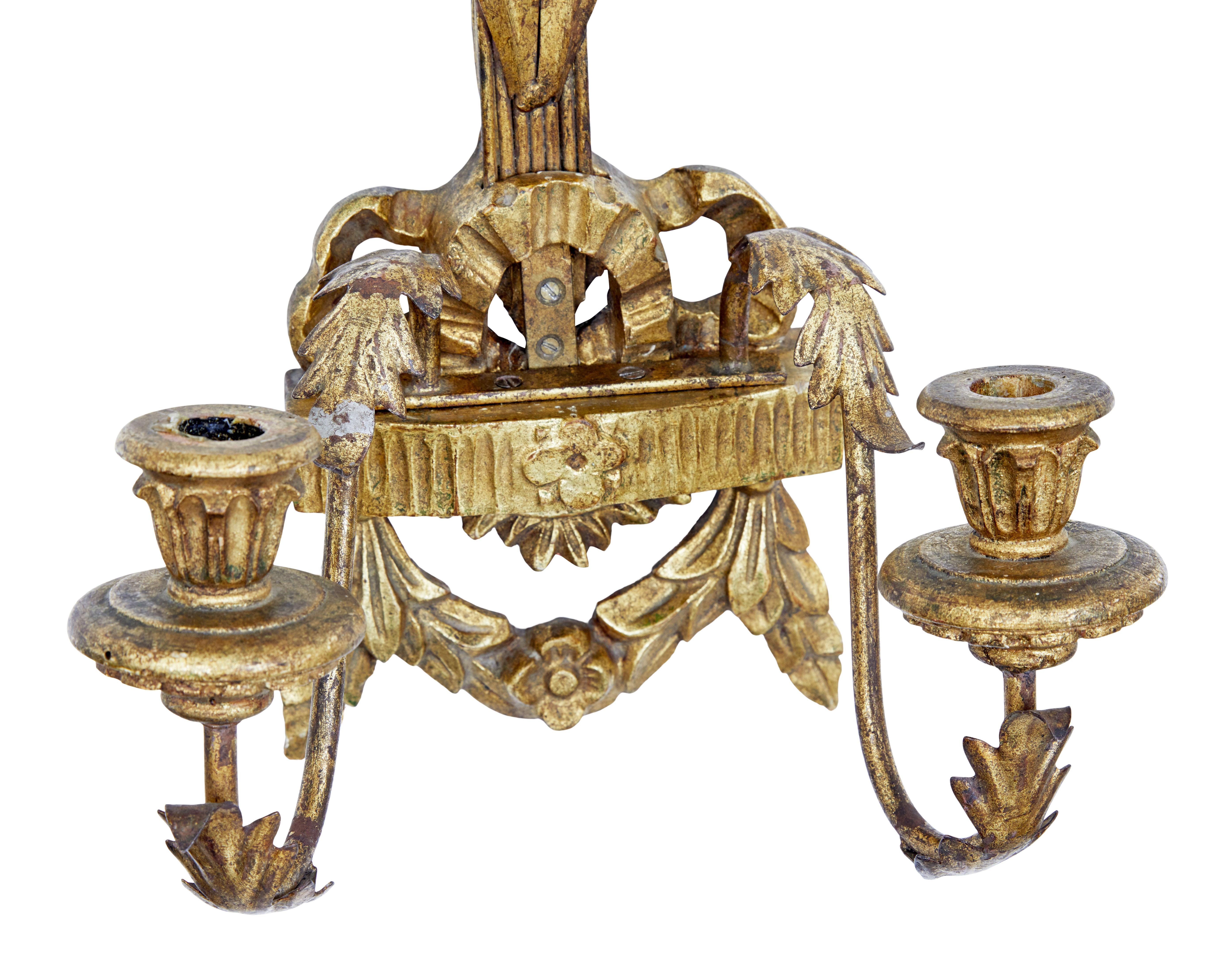 Early 20th century carved wood and gilt metal sconce, circa 1910.

Decorative 2 arm wall sconce. Decorated with ears of corn onto the main body of swags and leaves. Made with carved wood and metal elements.

Some expected gilt loss and off