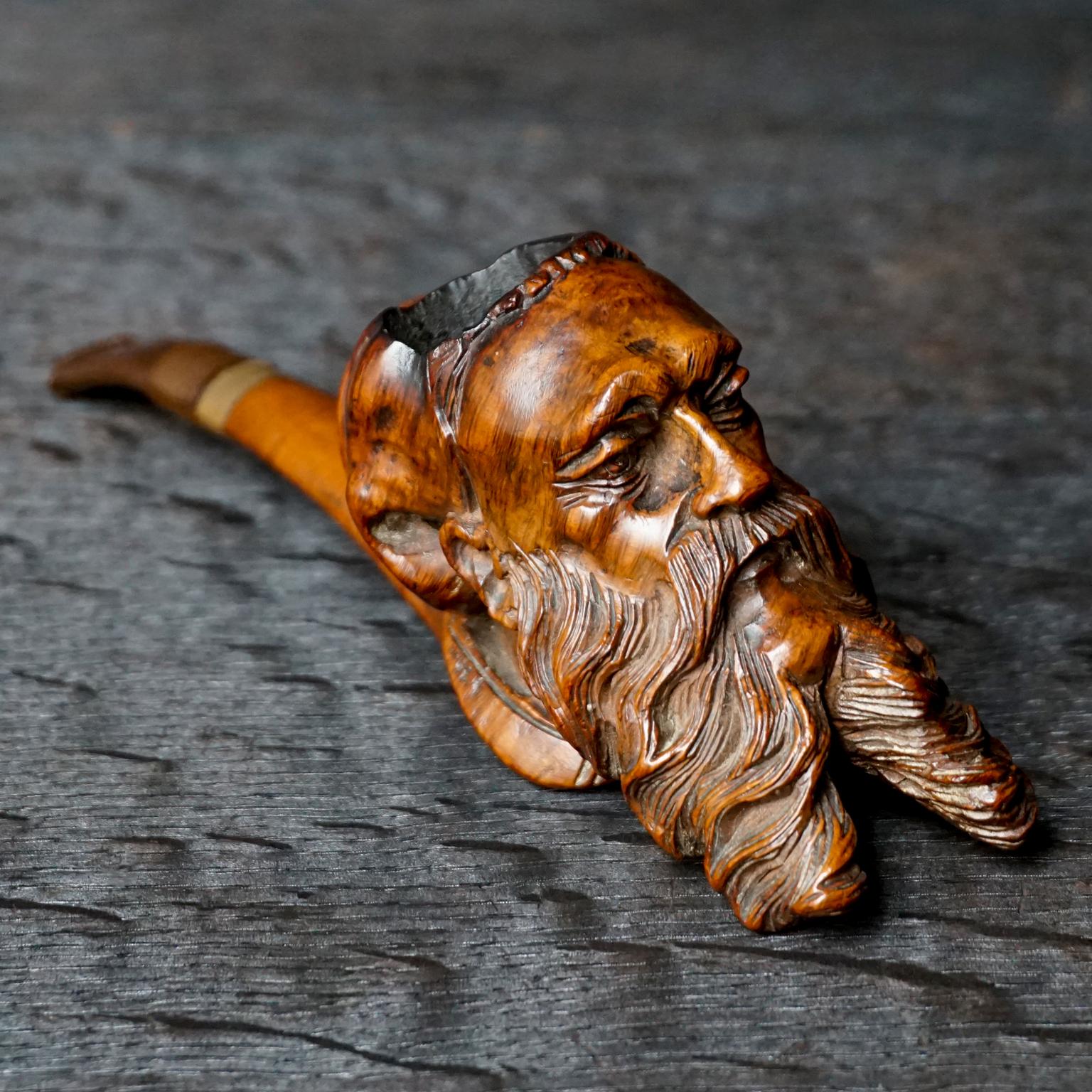 Impressive craftsmanship on the carving of this antique bearded man with nightcap, better known as Mr. Sandman.

The bakelite mouthpiece is probably not original and could easily be replaced for a new one to make a fresh smoking start. 
The metal