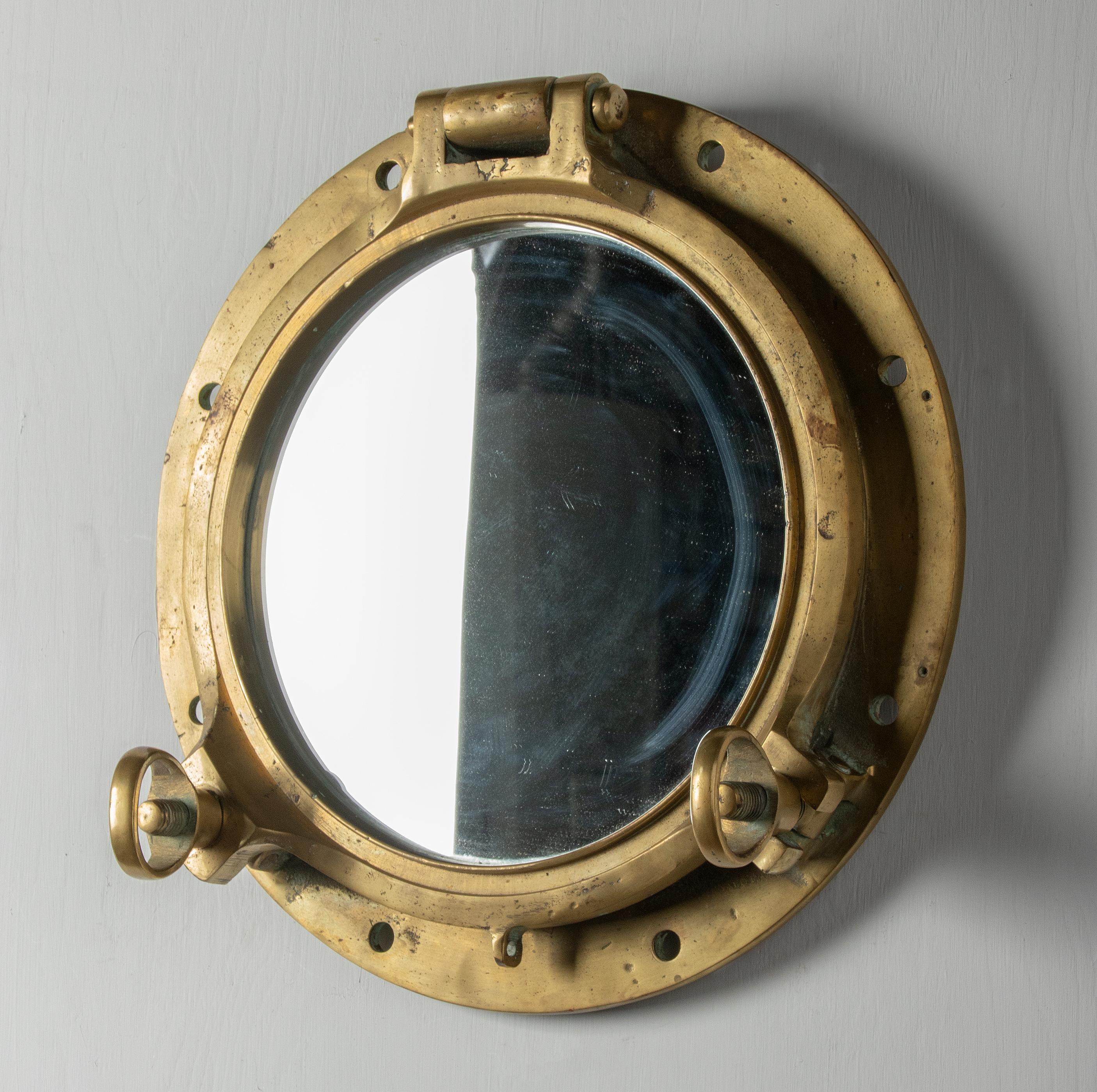 An antique heavy duty ship porthole wall mirror made of brass. A mirror glass has been placed inside. The whole has a beautiful old patina. This maritime object was made around 1900-1930, origin unknown.

The dimensions are 45 cm x 45 x 12 cm