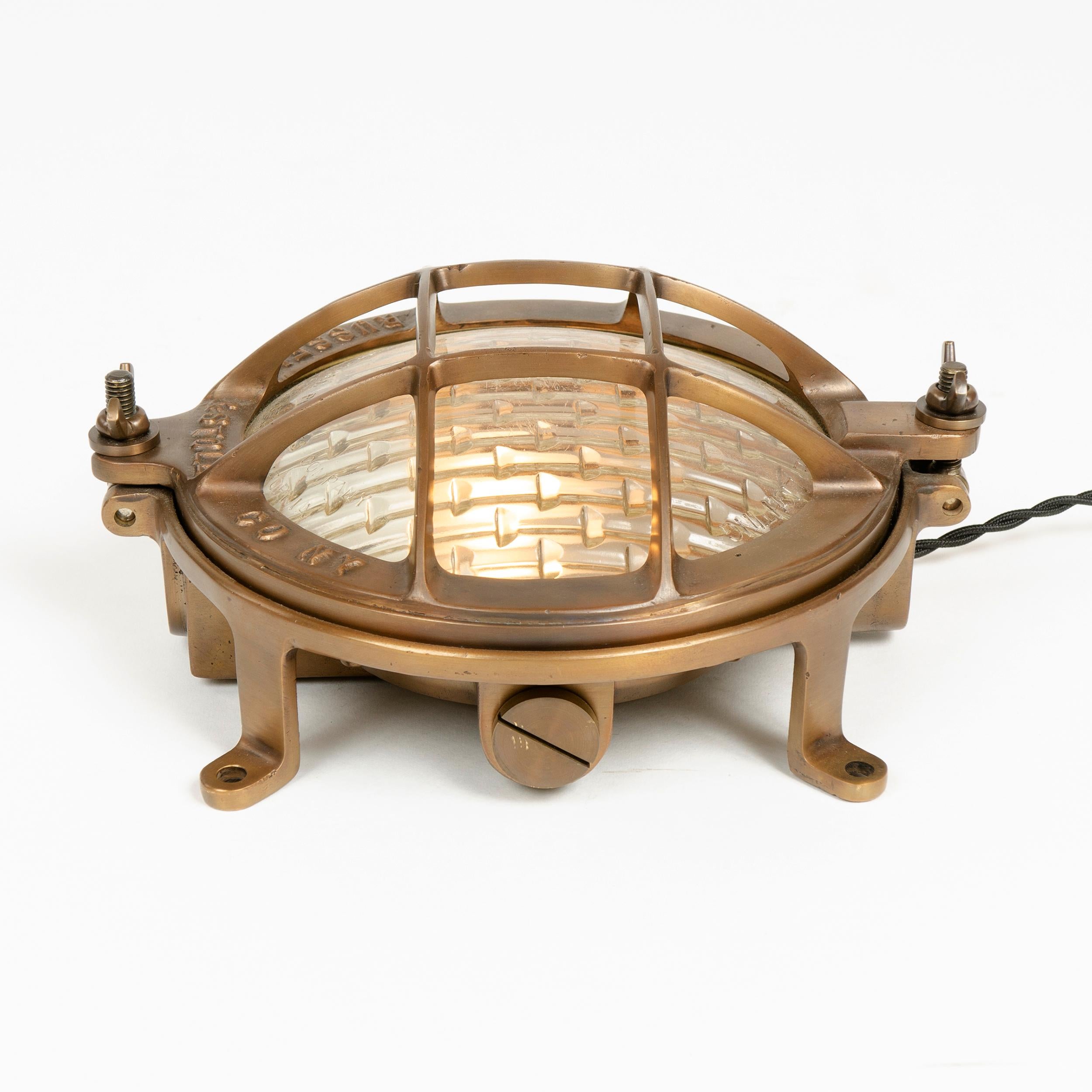 An excellent cast bronze sconce or ceiling mount lamp on a footed base with a glass dome protected by a well designed bronze cage.
