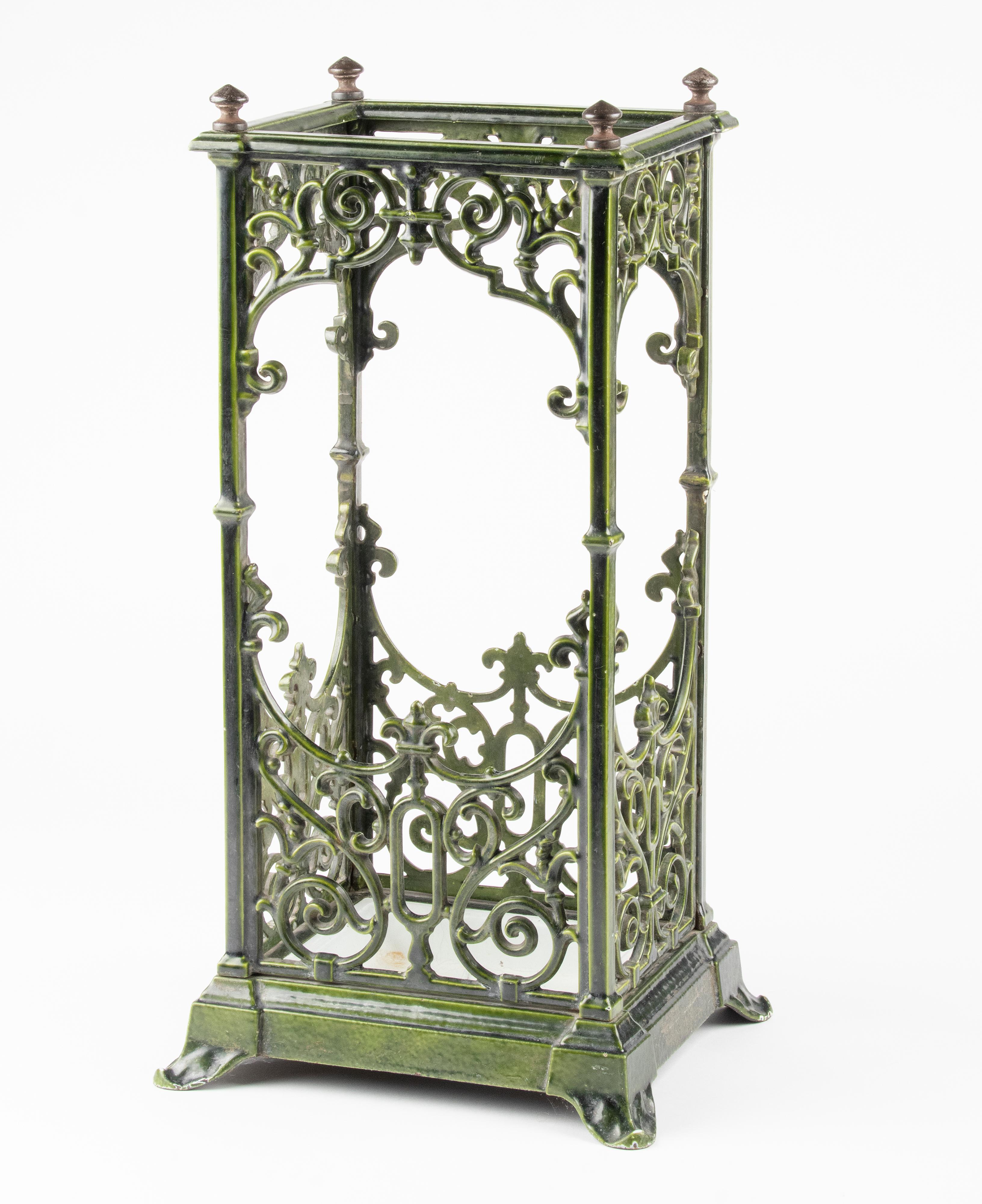 Beautiful antique umbrella stand. Made of heavy cast iron, enamelled in beautiful green color. The white tray at the bottom is removable. The umbrella stand is in very nice condition, with minor signs of age. One small curl ornament is missing, see