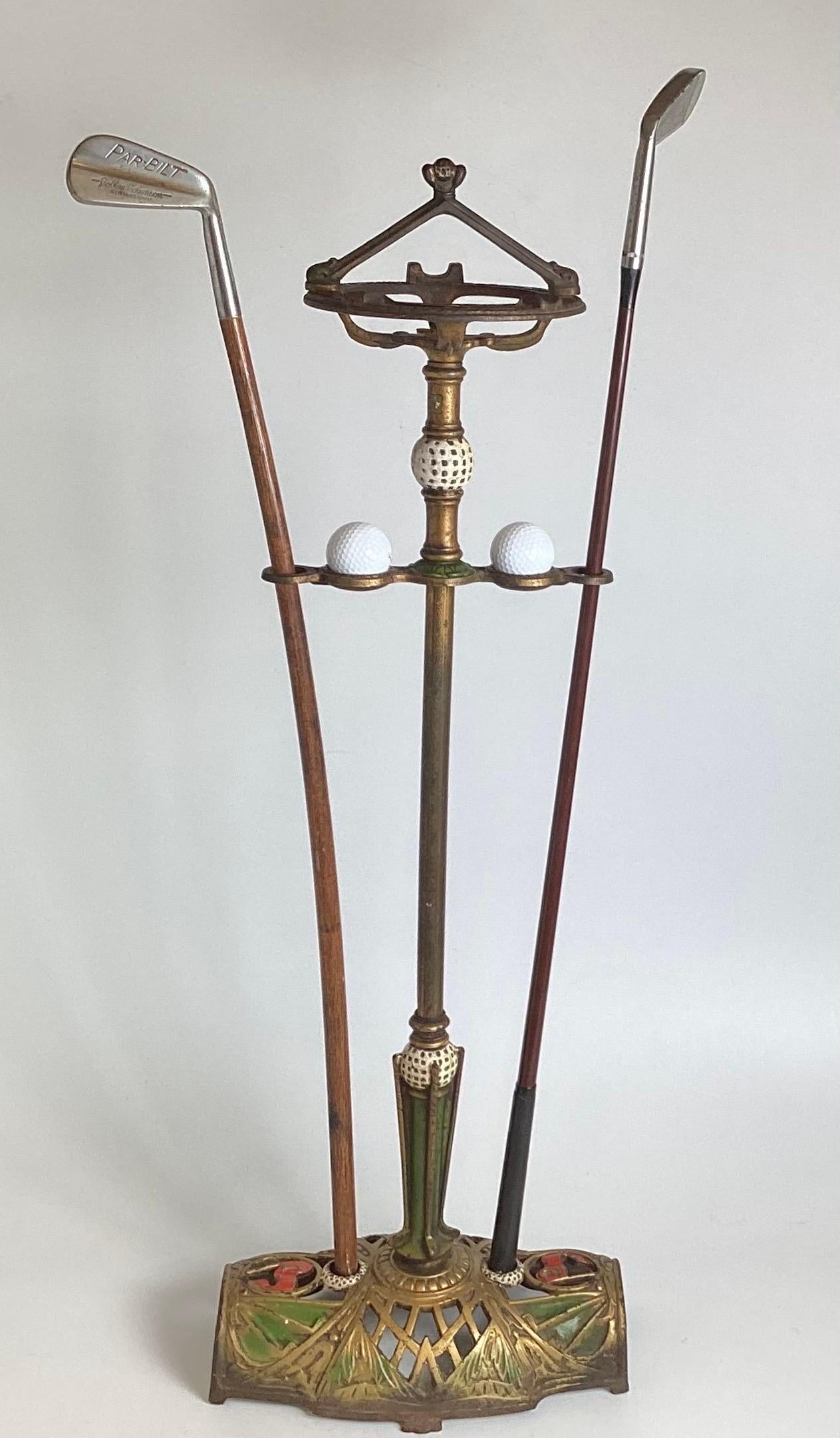 Un intéressant fumoir en fer forgé peint à froid.  Le support sur le thème du golf avec un espace pour les balles de golf et 2 clubs de golf, le cendrier supérieur est manquant.  34,5 pouces de haut, 12 pouces de large, 7 pouces de profondeur. 