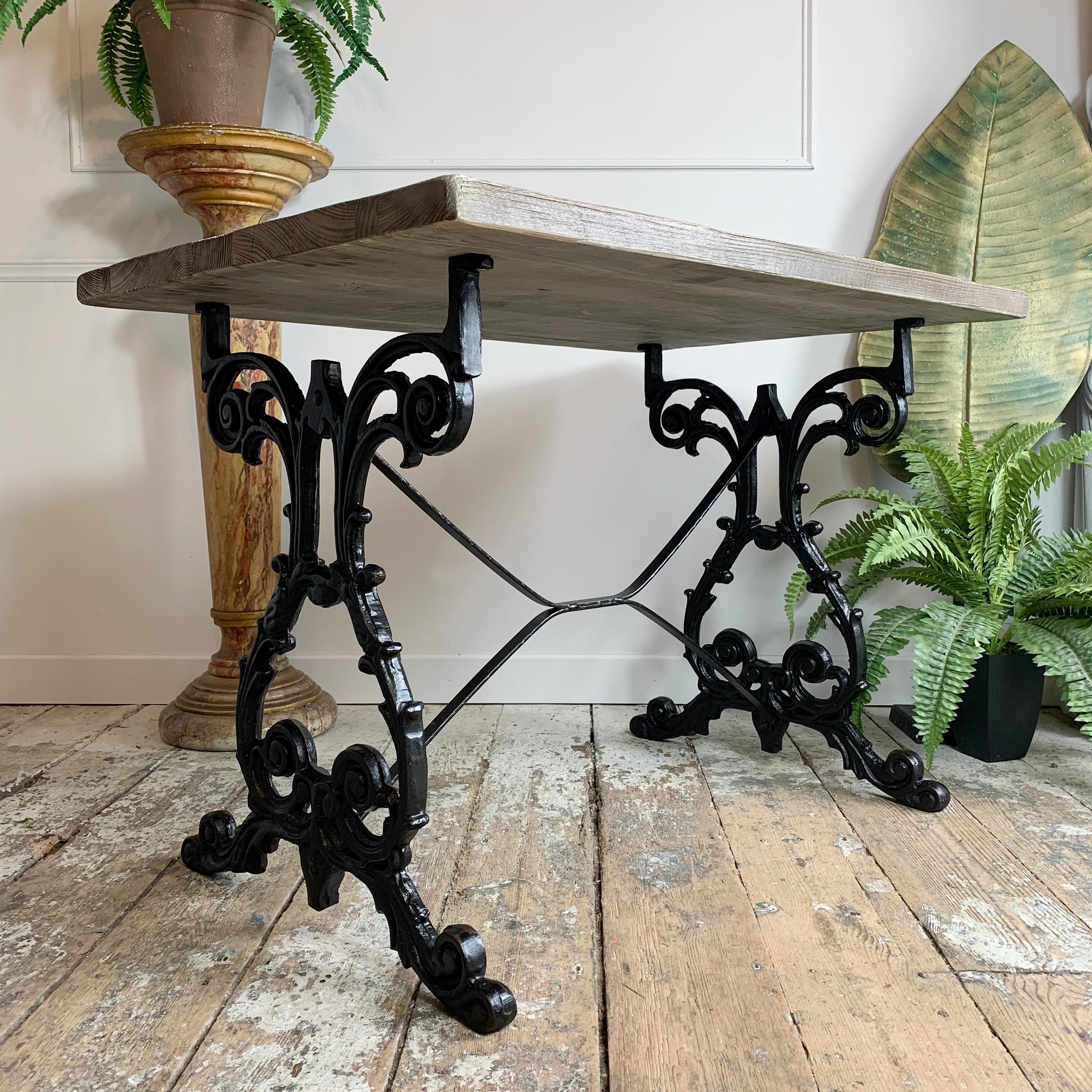 A beautifully cast table, dating to the early 20th century, the legs have been recently refurbished in black, and the top is a bespoke wood worker made thick reclaimed pine, finished in a specially formulated grey-silver wood stain, which blends