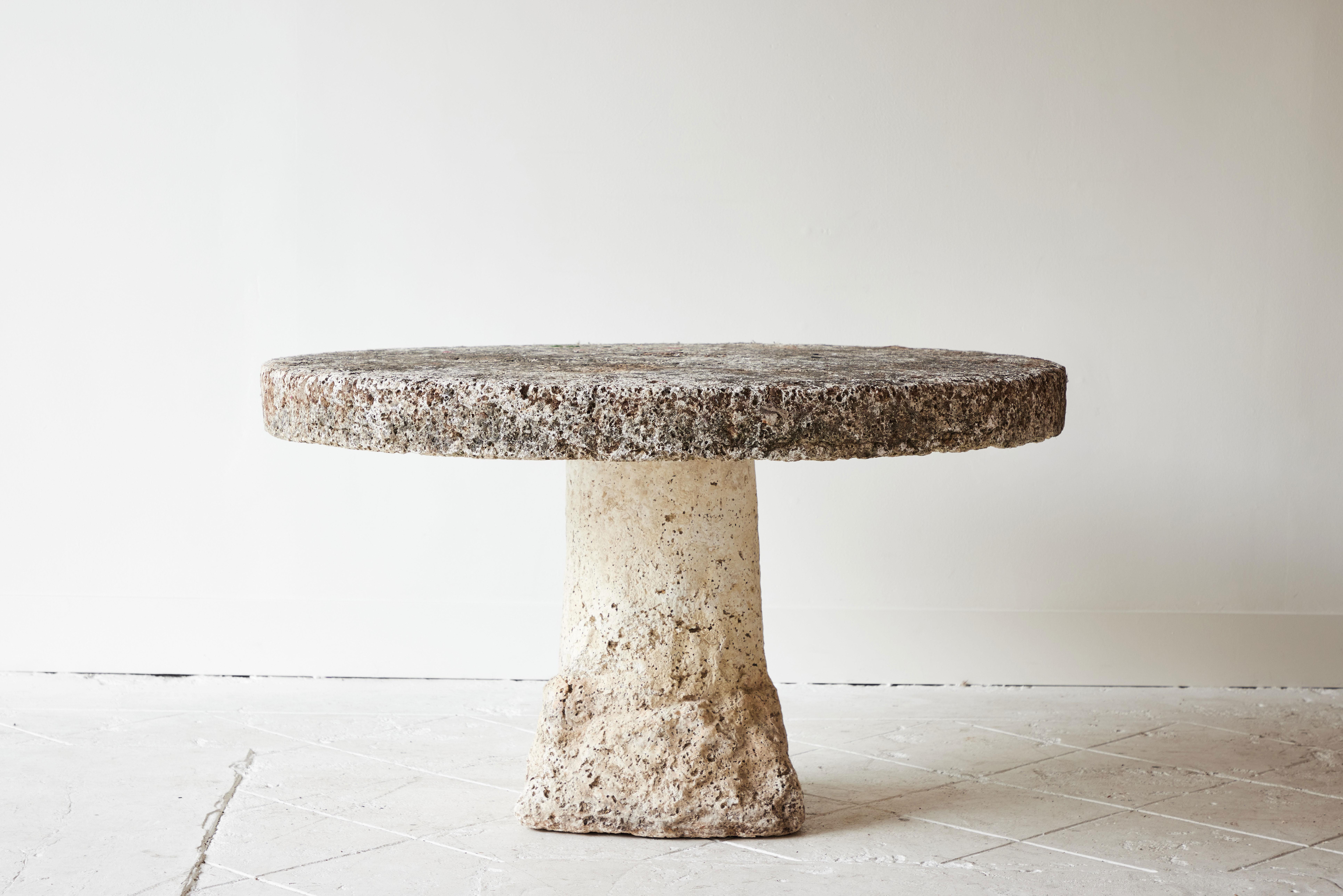 Fanciful cast stone round garden table with textured base from France, early circa 20th century. The shape evokes that of a mushroom. Weathering from the elements has added great character and texture to this unique piece. A small hole is featured