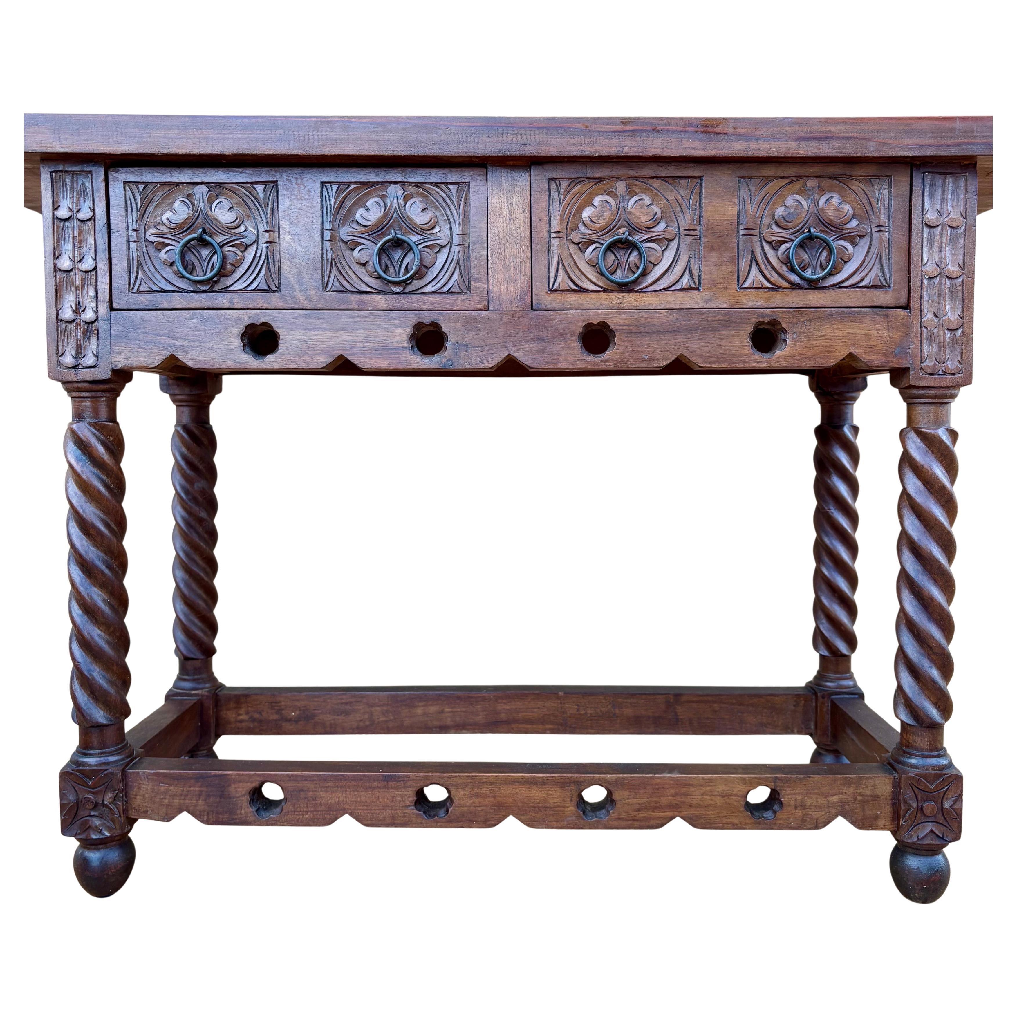 Early 20th century walnut console table with slab top on a frieze with two drawer fronts decorated with carved and incised floral motifs with additional decoration and two original iron pulls on each drawer. The table rests on a hand-carved base