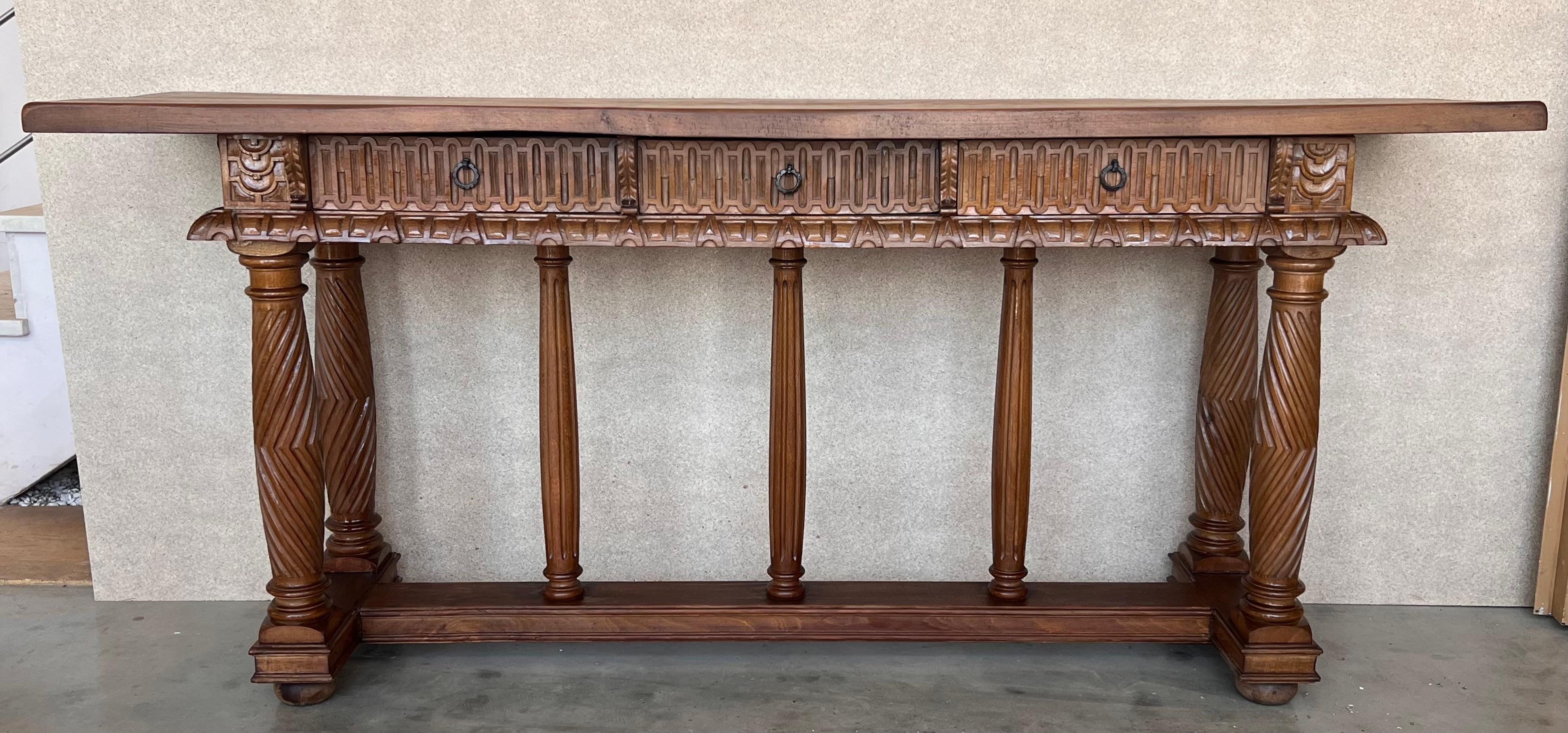 Late 19th century catalan spanish hand carved walnut console table with three drawers and Solomonic legs. The piece has a three central columns to support the large top and drawers. Original hardware.
Very good quality carved Spanish console table,