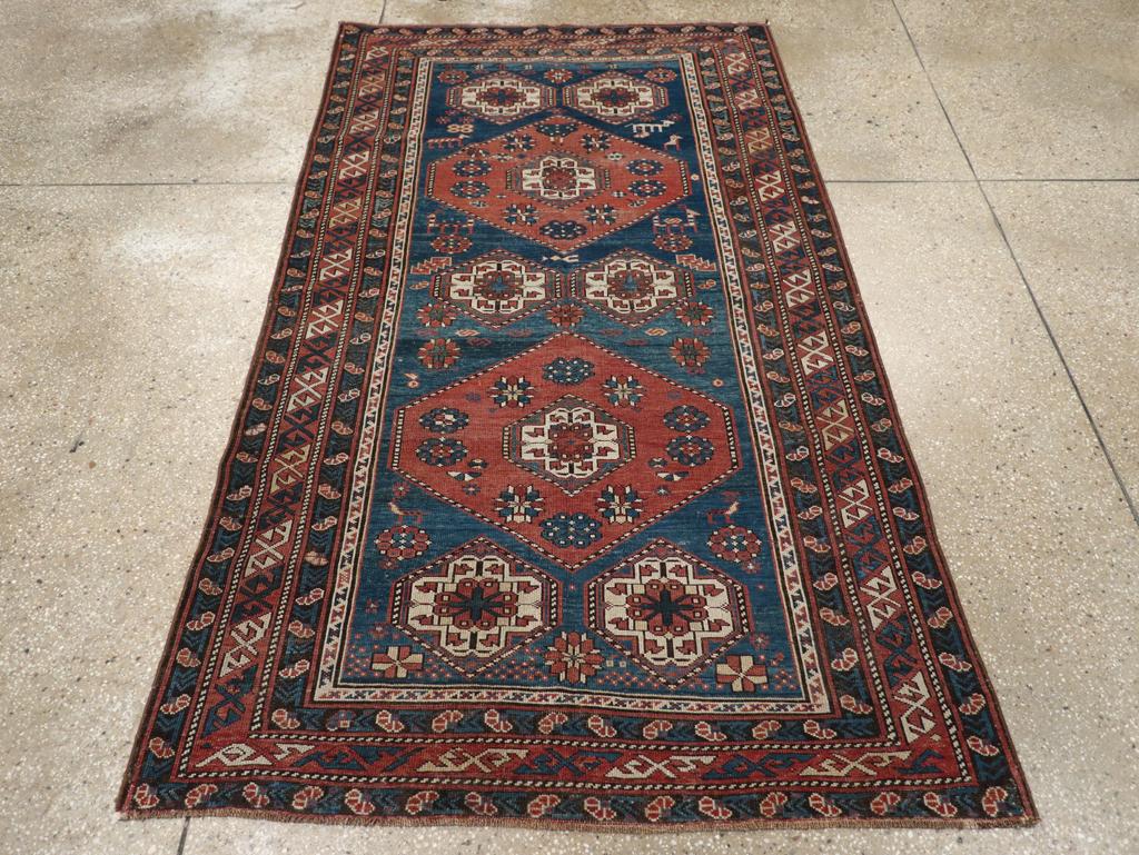 Un ancien tapis d'accent caucasien Kazak. Le fond bleu royal de cette pile basse d'objets épars du Caucase oriental présente deux médaillons hexagonaux rouges et des paires de motifs gul plus petits en ivoire. La bordure en S barré est typiquement