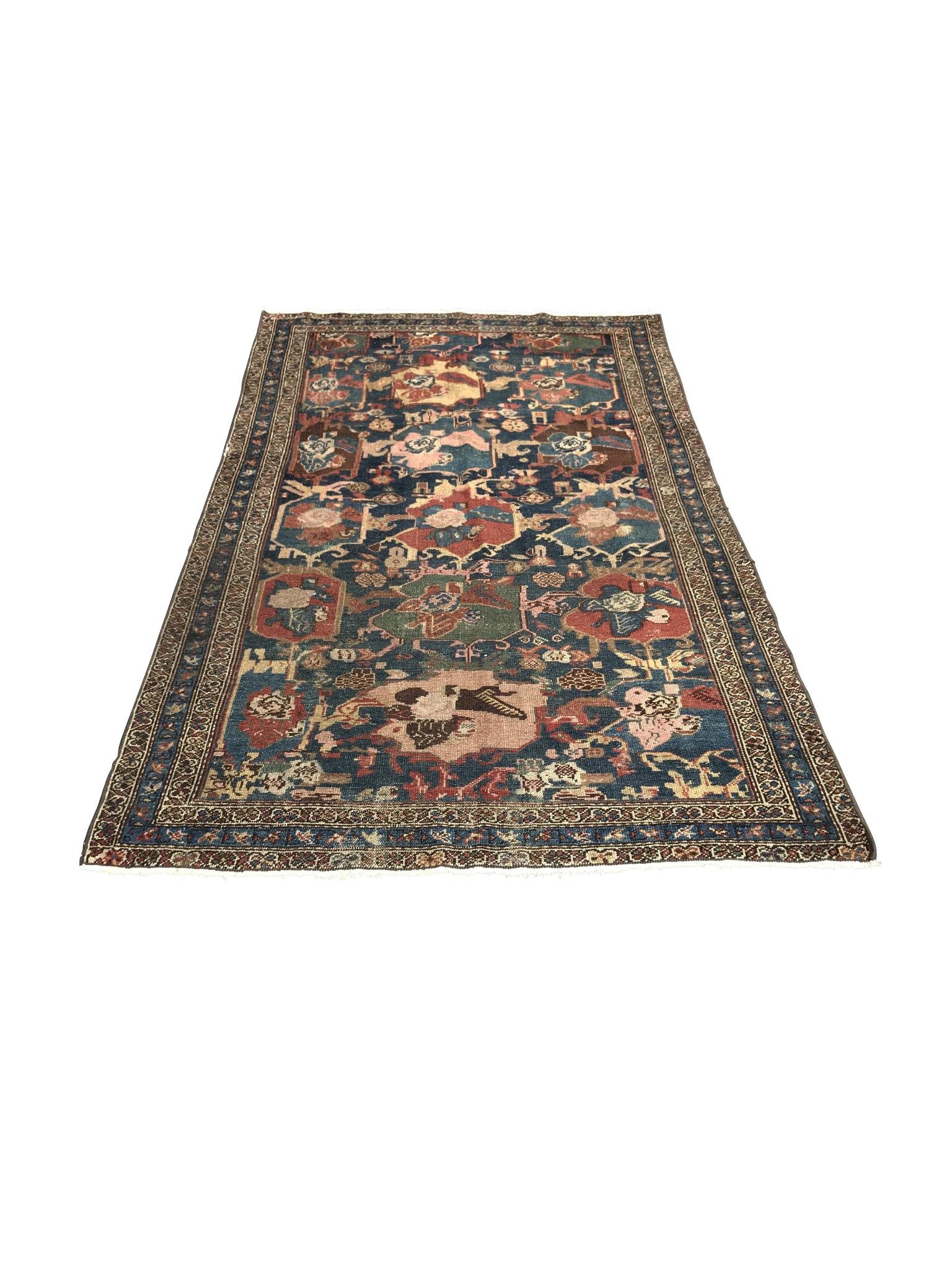 A richly patterned and colorful Caucasian rug, made in the early 20th century. The woven wool is dyed with a palette of blues, pinks, greens, and yellow-beiges - all arranged in an all-over design of winding floral motifs. A series of bands in the