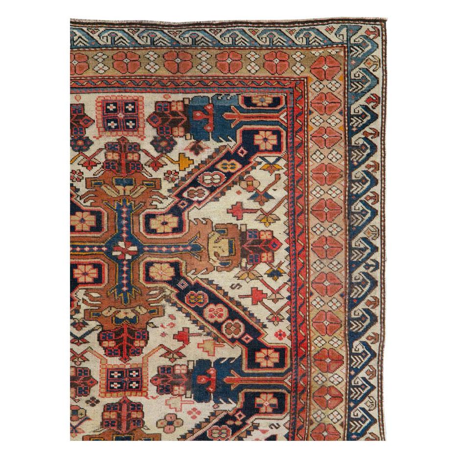 An antique Caucasian Seychour (Zeychur) accent rug handmade during the early 20th century featuring two dark blue and rust St. Andrew’s Oblique Crosses to design the ivory field.

Measures: 4' 0