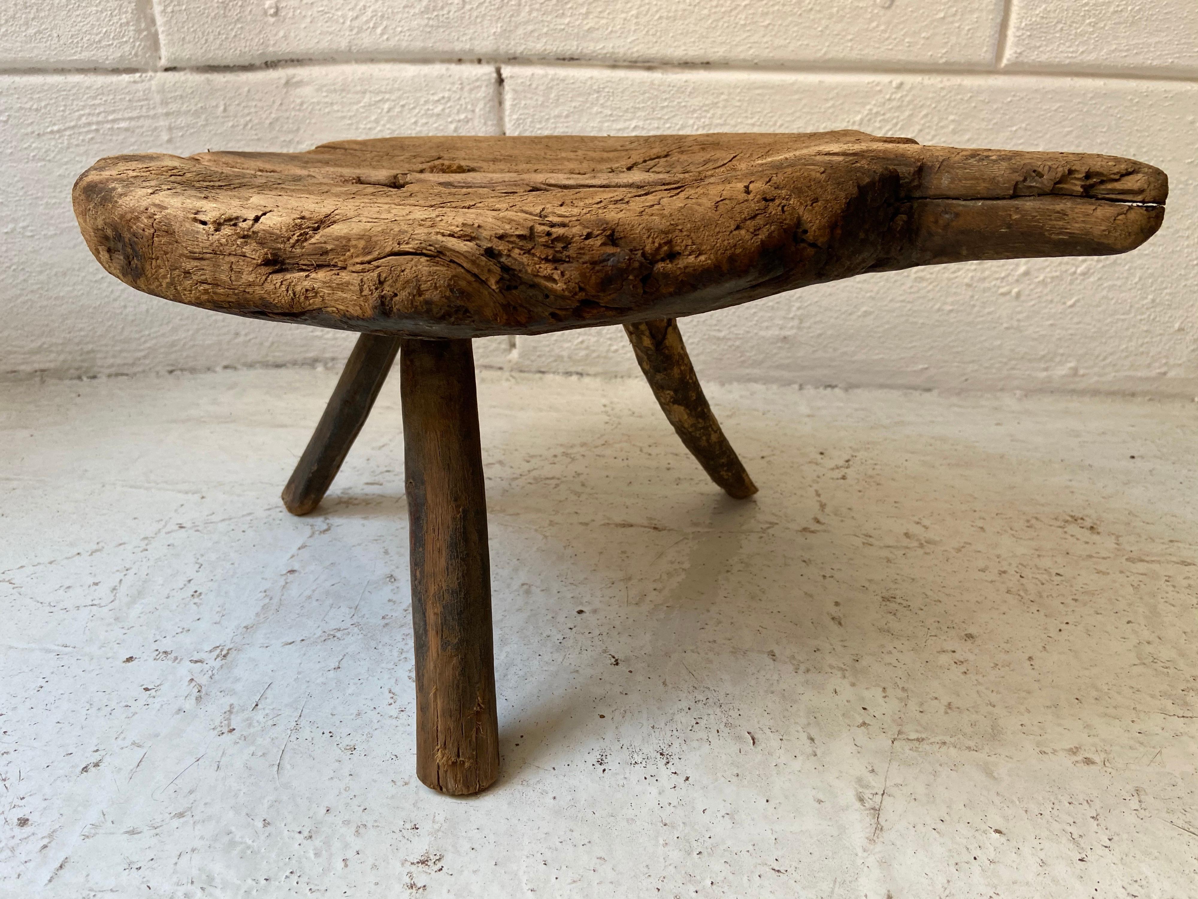 1920s cedar tripod work stool from Tamazunchale, San Luis Potosi, Mexico. Heavily weathered patina and wood grain. All legs are original and structurally solid.