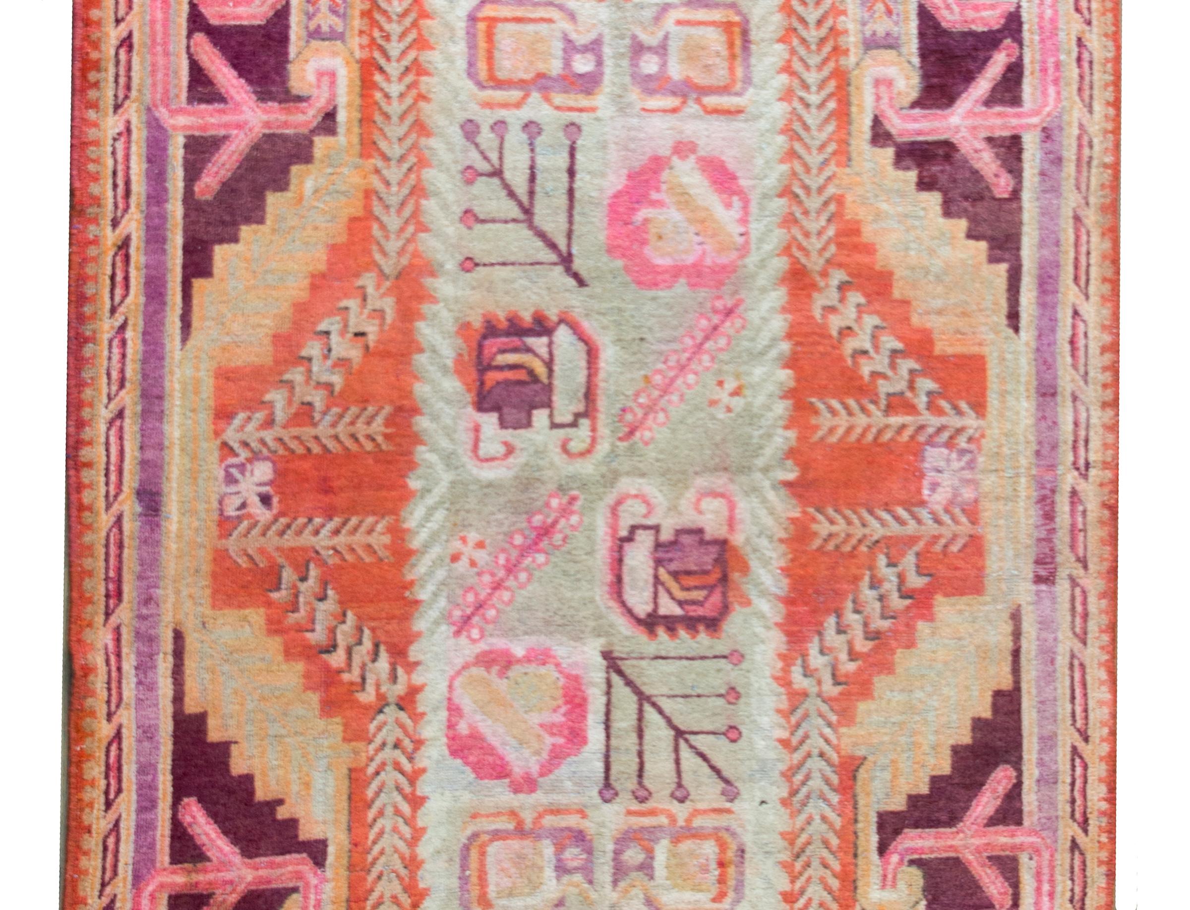 Superbe tapis Khotan d'Asie centrale du début du 20e siècle. Le champ central est magnifique, avec des fleurs et des feuilles stylisées, entouré d'une bordure de style baroque avec d'autres fleurs stylisées, le tout tissé dans d'incroyables roses,