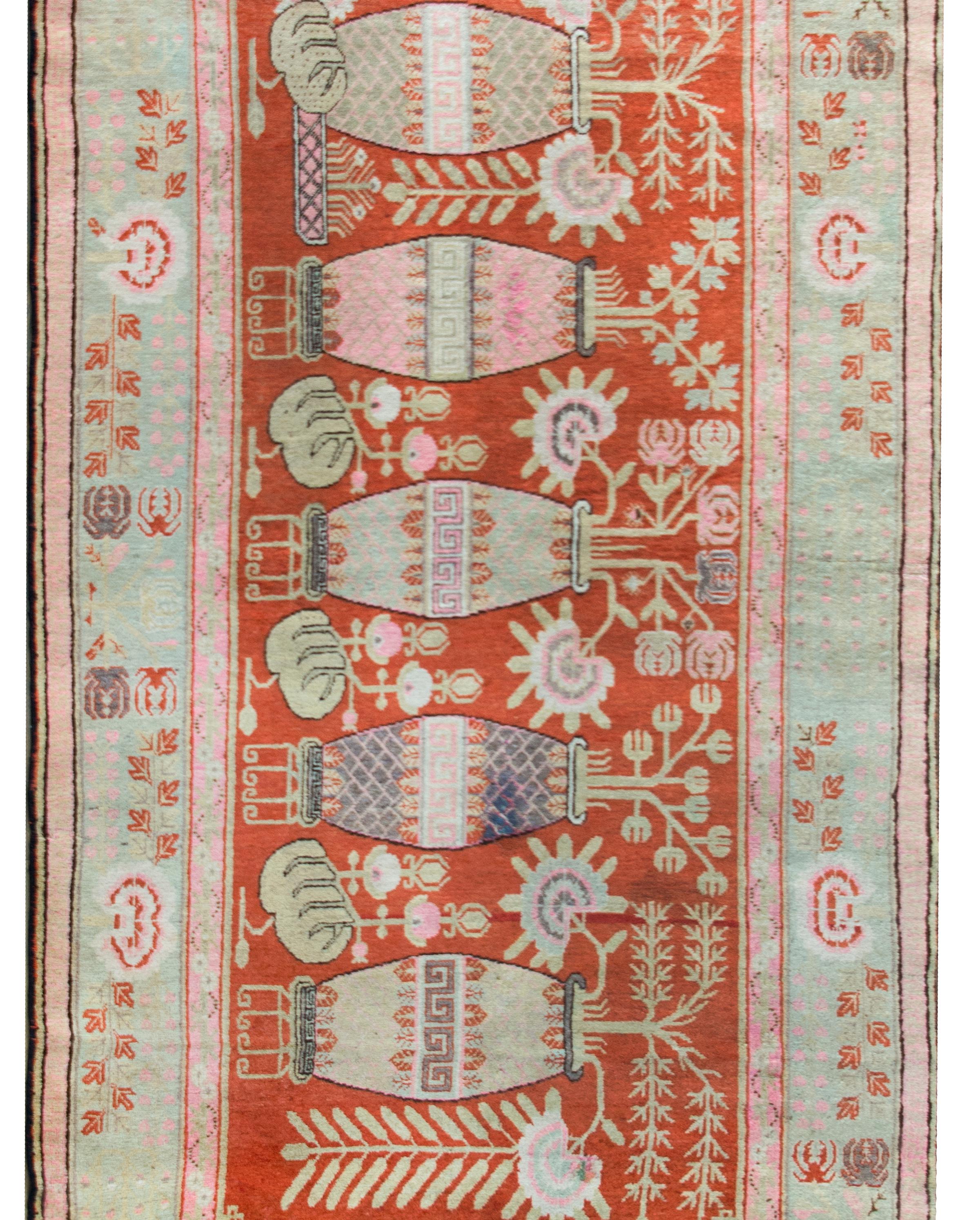 Ein prächtiger zentralasiatischer Khotan-Teppich aus dem frühen 20. Jahrhundert mit fünf großen Vasen, die jeweils mit Pfingstrosen und Chrysanthemen sowie weiteren glücksverheißenden Blumen wie Lotos und Buddhas Händen bepflanzt sind.  Die breite